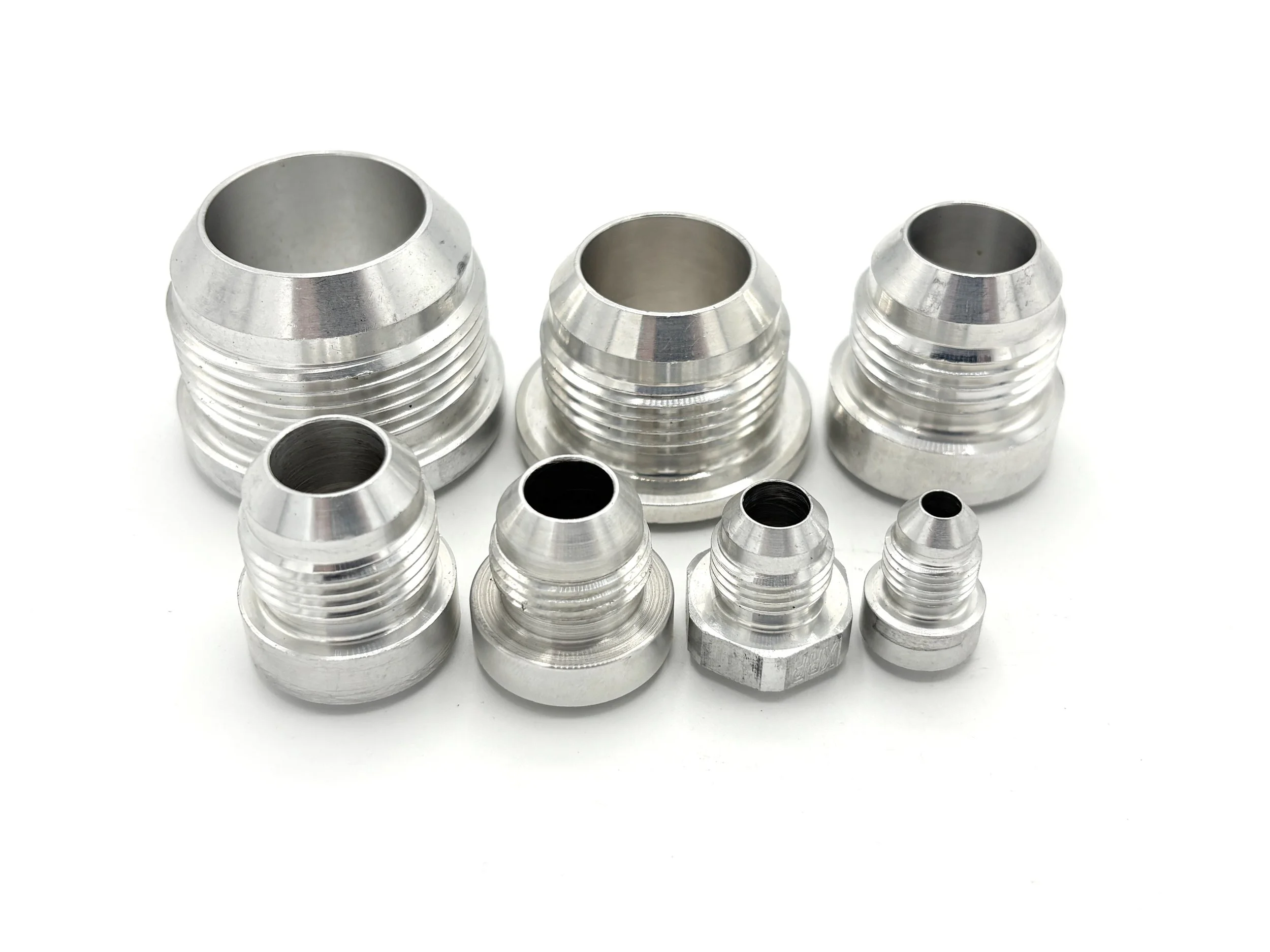 XRP AN Male Weld On Bung Aluminum. Silver in color. Various sizes from largest to smallest, left to right.