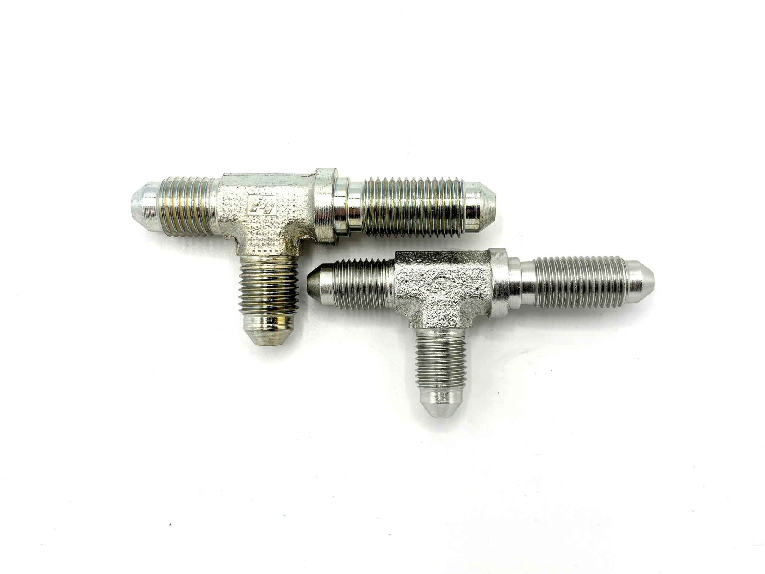 XRP AN steel bulkhead tee on run. Silver in color. Various sizes from largest to smallest, left to right.