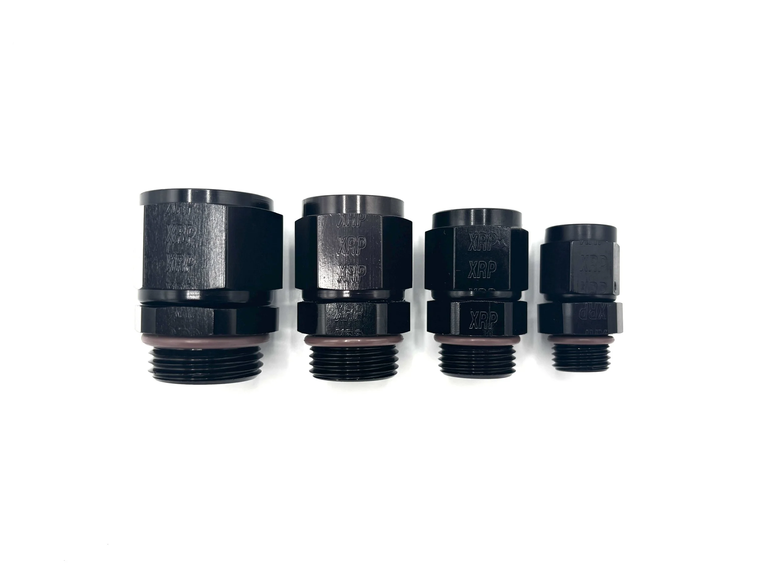 XRP Straight AN Female Swivel to ORB Fitting. Black in color. Brown O-ring on bottom. Various sizes in a line, largest to smallest, left to right.