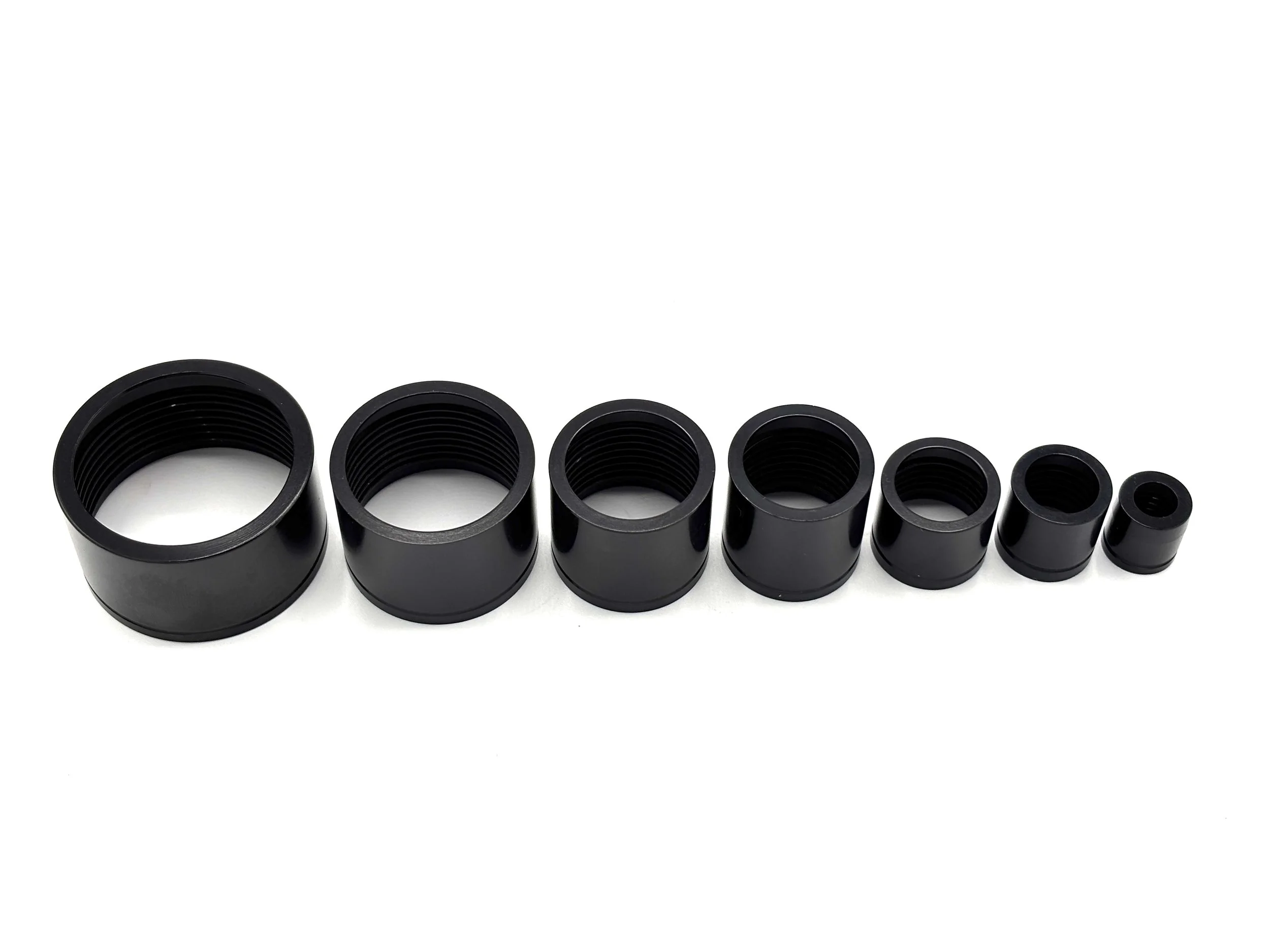 XRP HS-79 PTFE crimp collar. Black in color. Various sizes from largest to smallest, left to right.