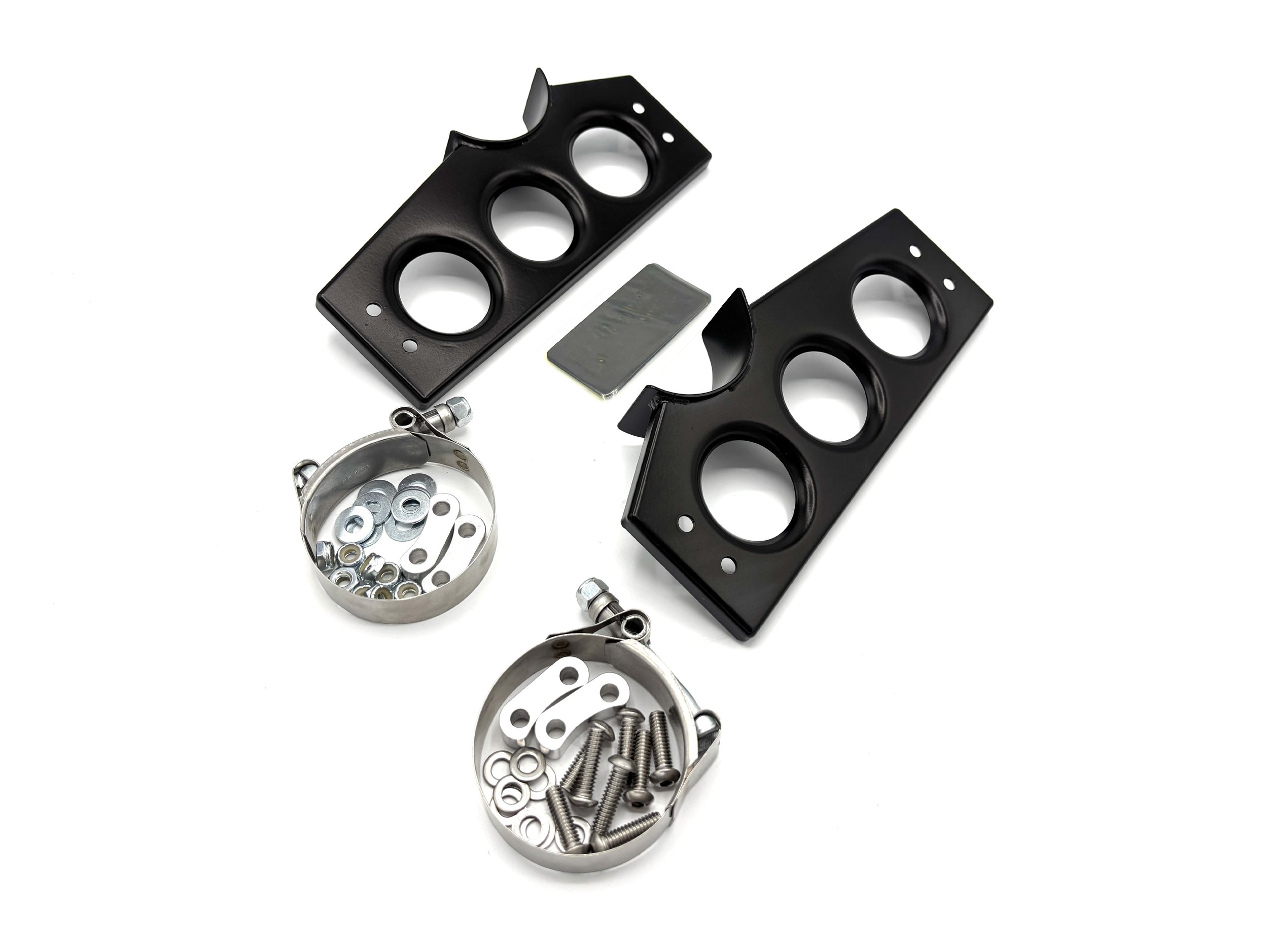 Two type one oil cooler brackets black powder coated. There are also black rubber pads in the middle of the brackets with two clamps and a bag full of hardware in front of the brackets.