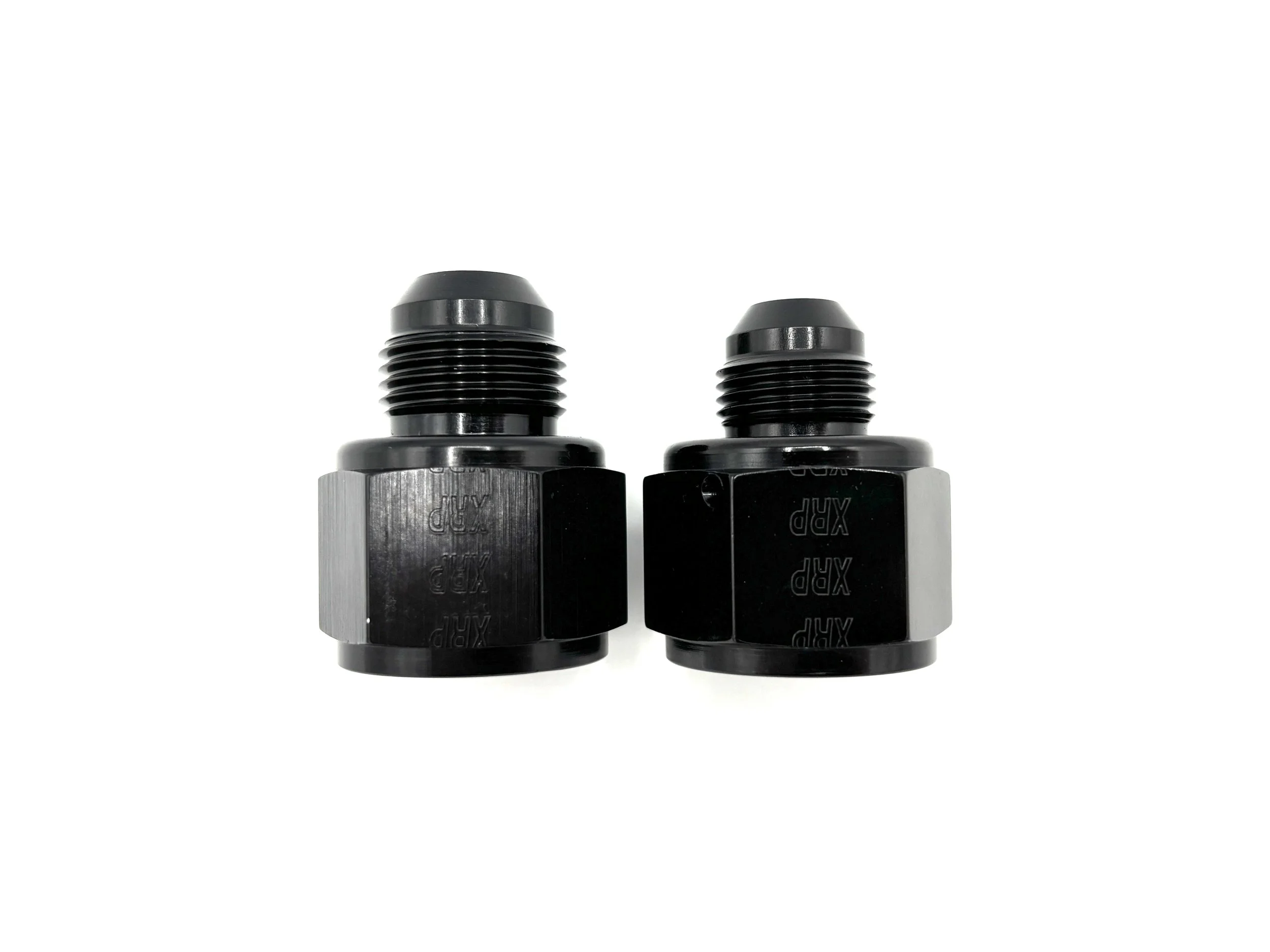 XRP straight -12AN female to AN male reducer fitting. Black in color. Various sizes from largest to smallest, left to right.