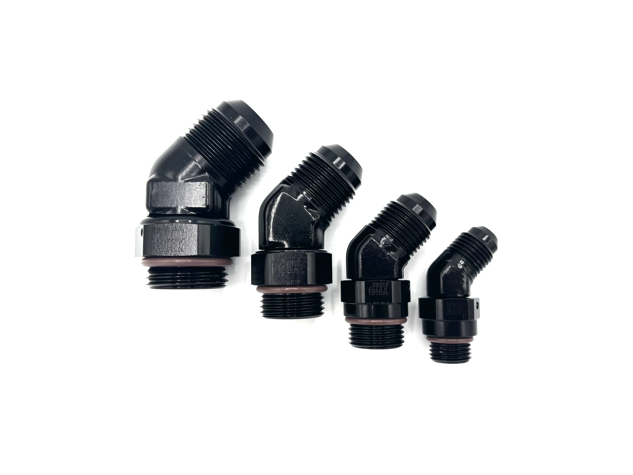 XRP 45 deg. forged -12AN male to -12 o-ring boss fitting. Black in color. Has brown viton o-ring on the bottom. Various in a line, in order from largest to smallest, left to right.