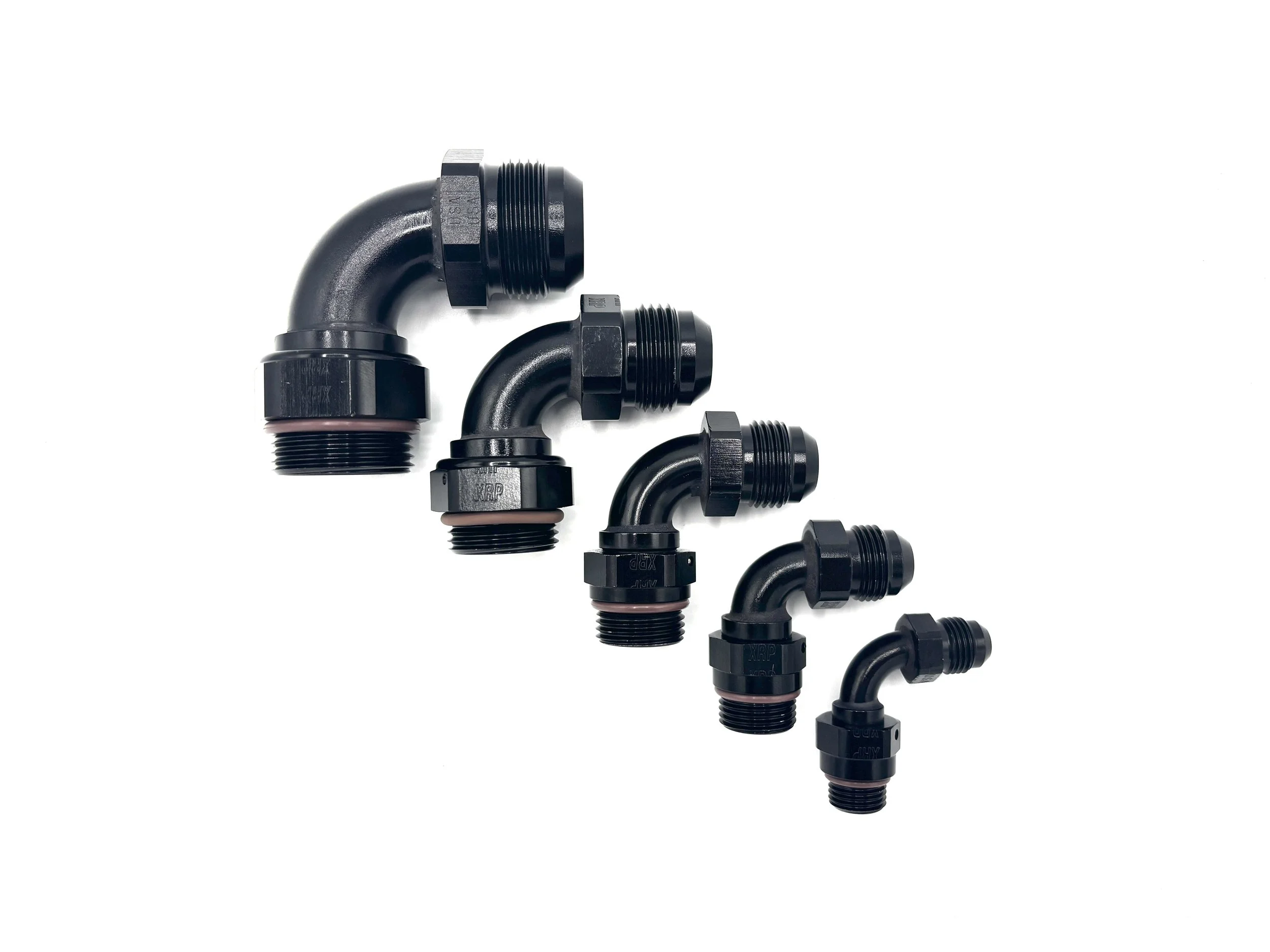 XRP 90 Deg. AN Male to ORB Fitting. Black in color. Brown O-ring on the bottom. Various sizes in order from largest to smallest, left to right.