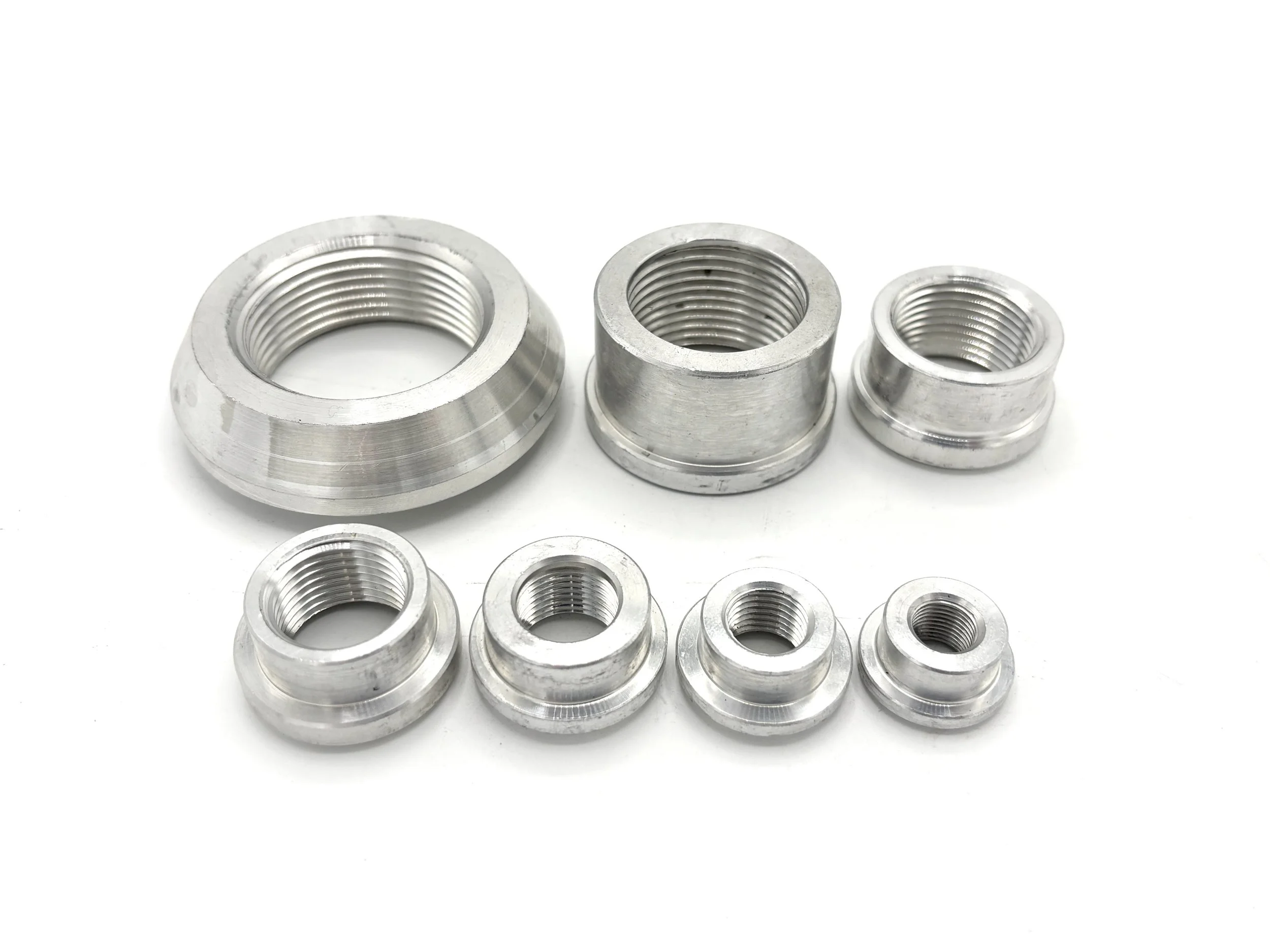 XRP NPT female aluminum recessed weld bung. Silver in color. Various sizes from largest to smallest, left to right.