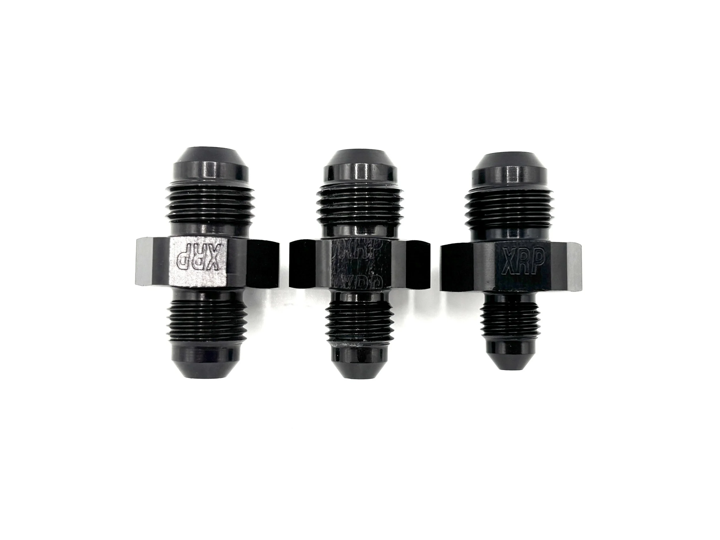XRP straight -6AN male reducer fitting. Black in color. Various sizes from largest to smallest, left to right.