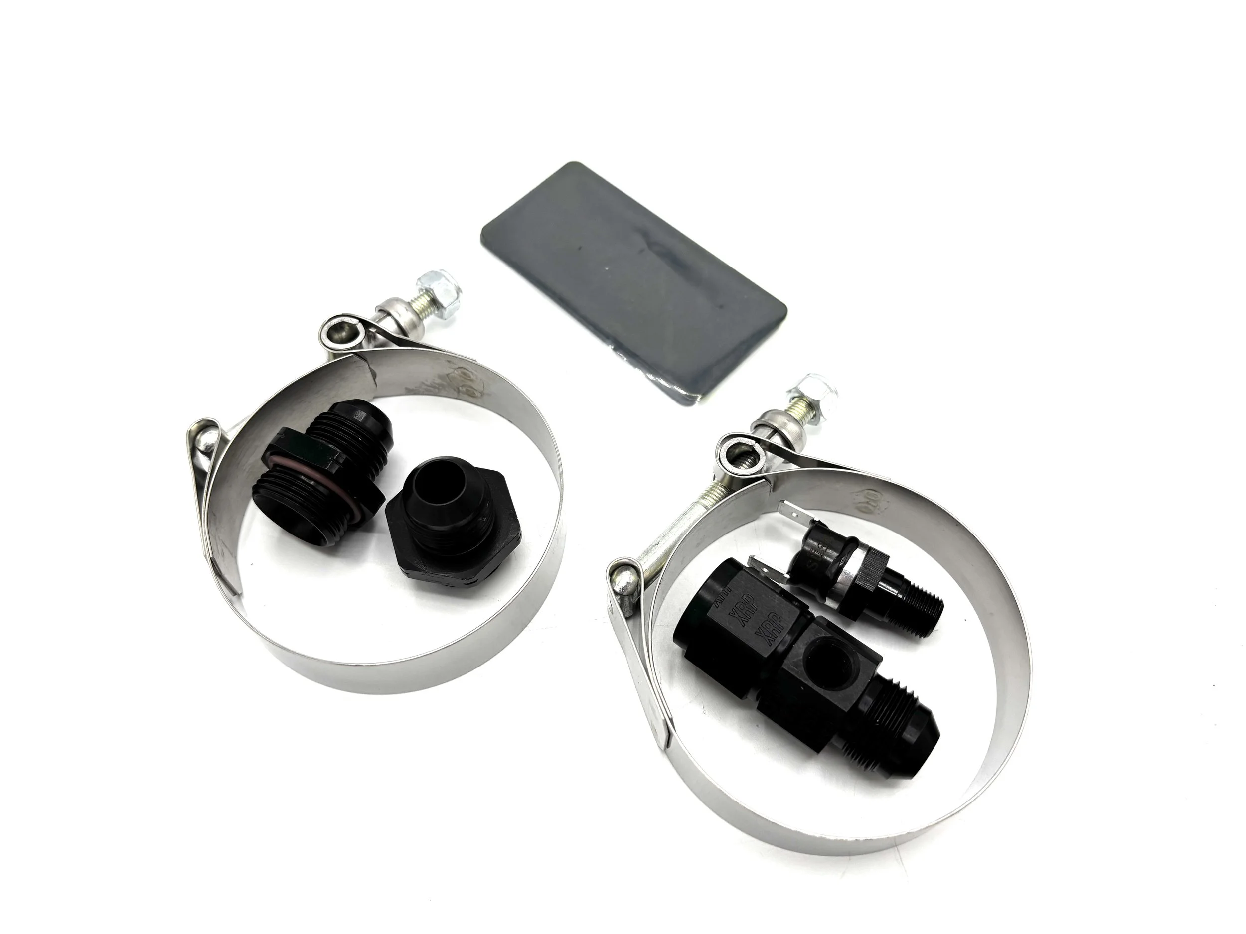 2 silver clamps with two black fittings in both of them. Two black rubber pads are next to it too.