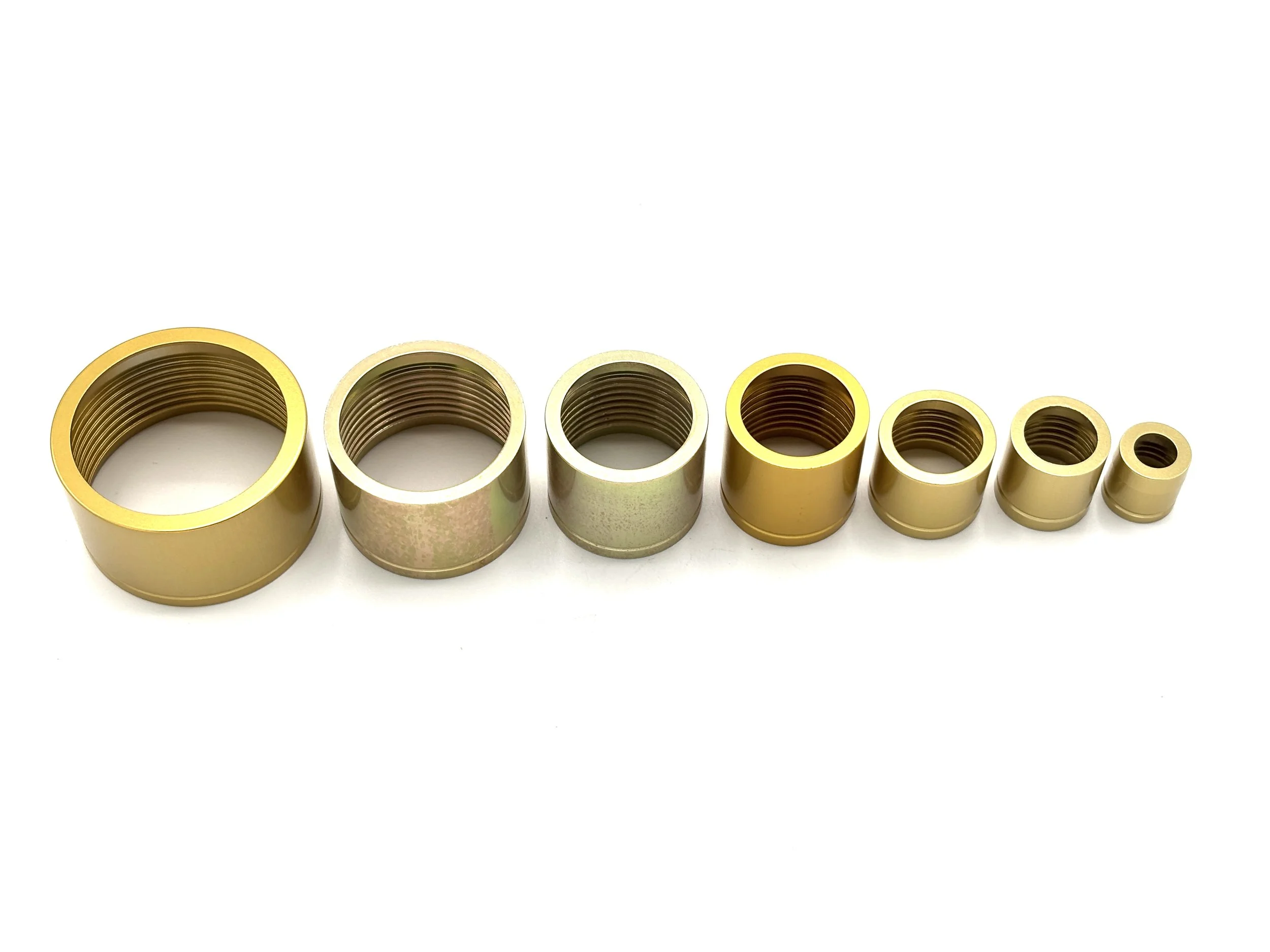 XRP HS-79 PTFE crimp collar. Gold in color. Various sizes from largest to smallest, left to right.