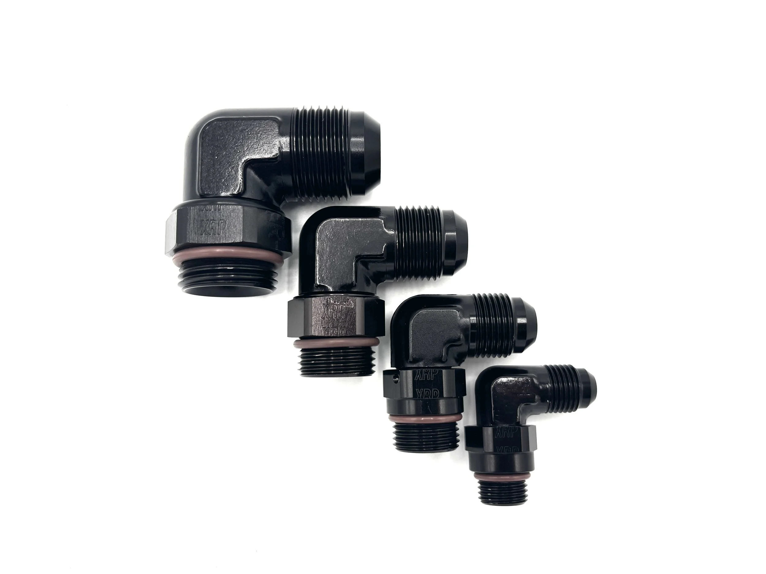 XRP 90 deg. forged -12AN male to -12 o-ring boss fitting. Black in color. Has brown viton o-ring on the bottom. Various sizes from largest to smallest, left to right.
