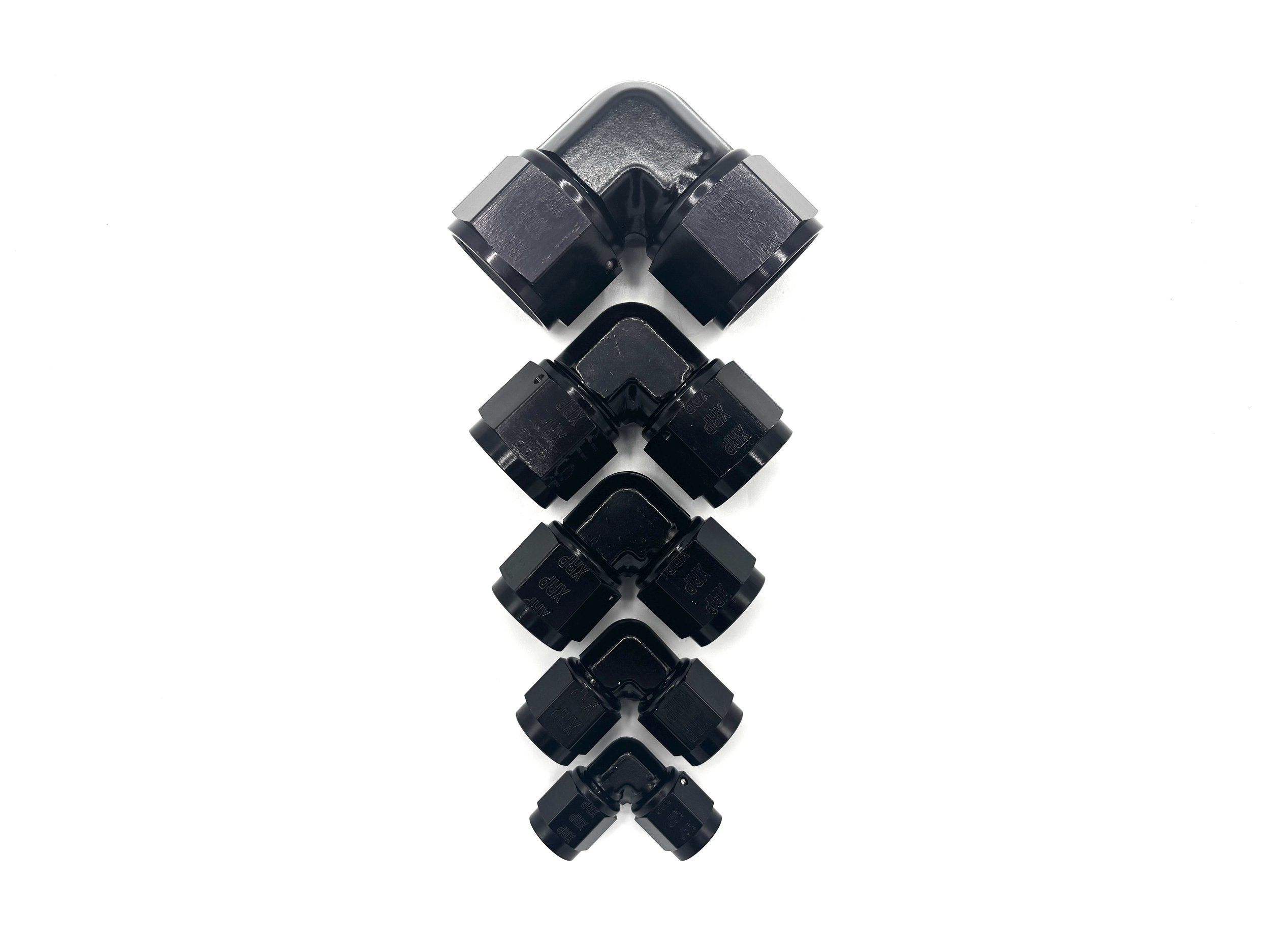 XRP 90 deg. forged -12AN female to -12AN female coupler. Black in color. Various in a line, from largest to smallest, left to right.