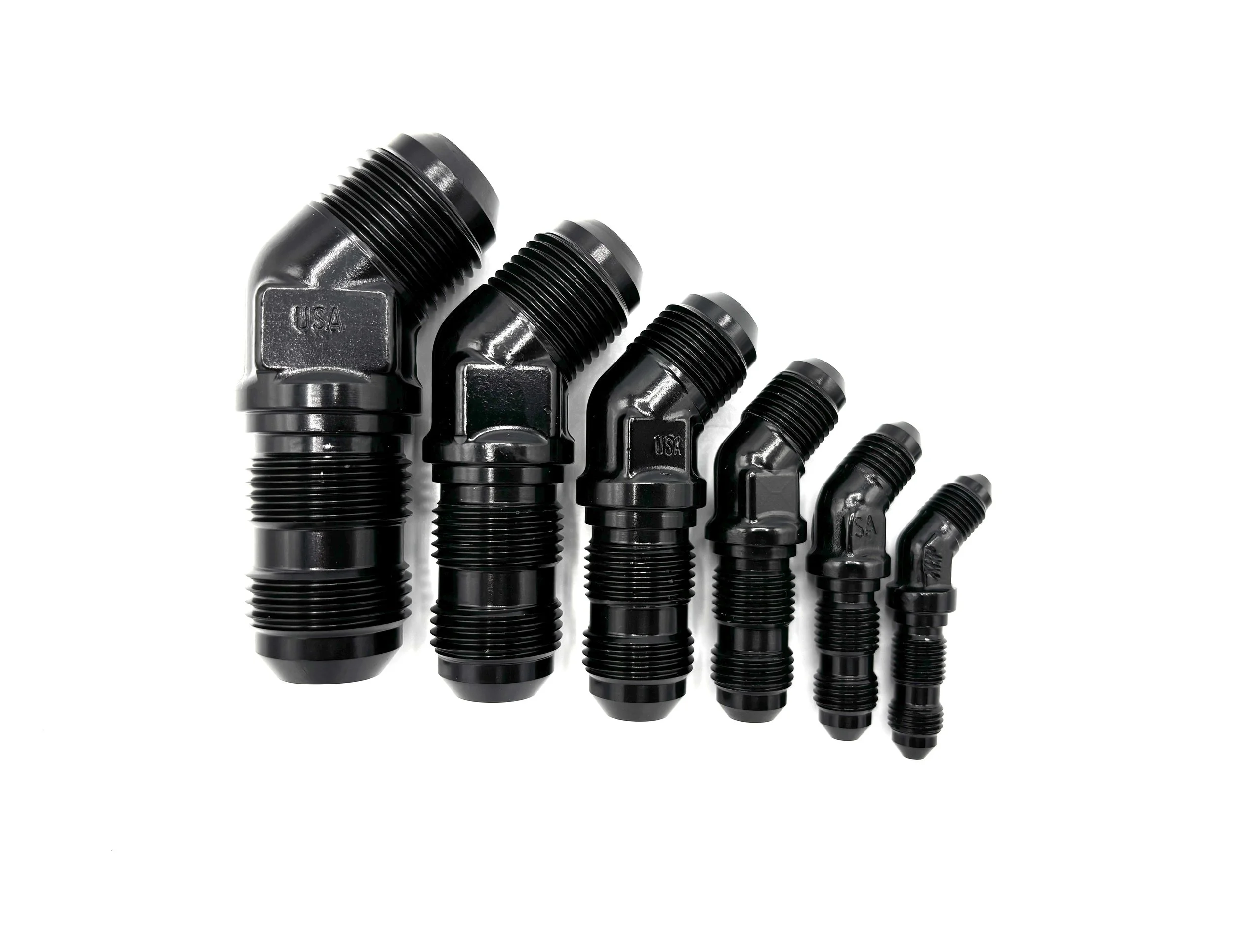 XRP 45 deg. bulkhead adapter fitting. Black in color. Various sizes from largest to smallest, left to right.