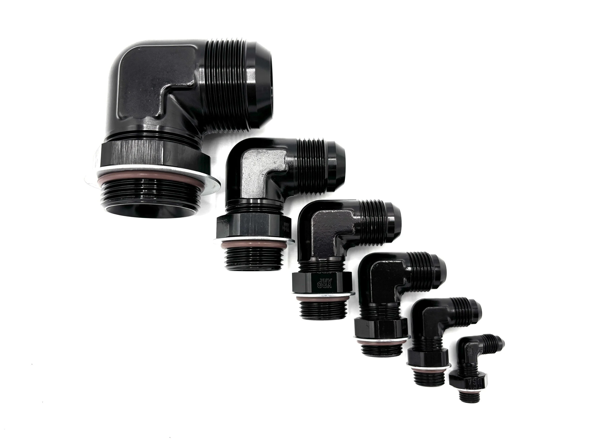 XRP 90 deg. AN male to o-ring boss adapter fitting. Black in color. Has nut, washer, and o-ring on it. Various sizes from largest to smallest, left to right.