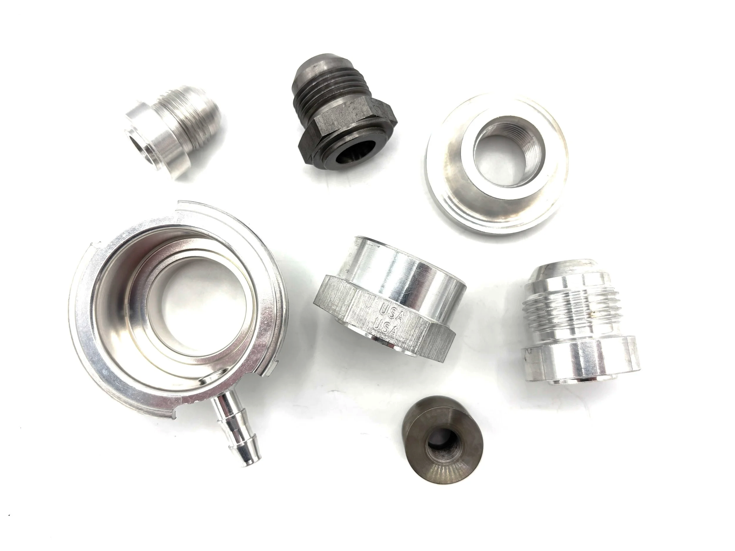 Assorted weld on adapter fittings, on a white background.