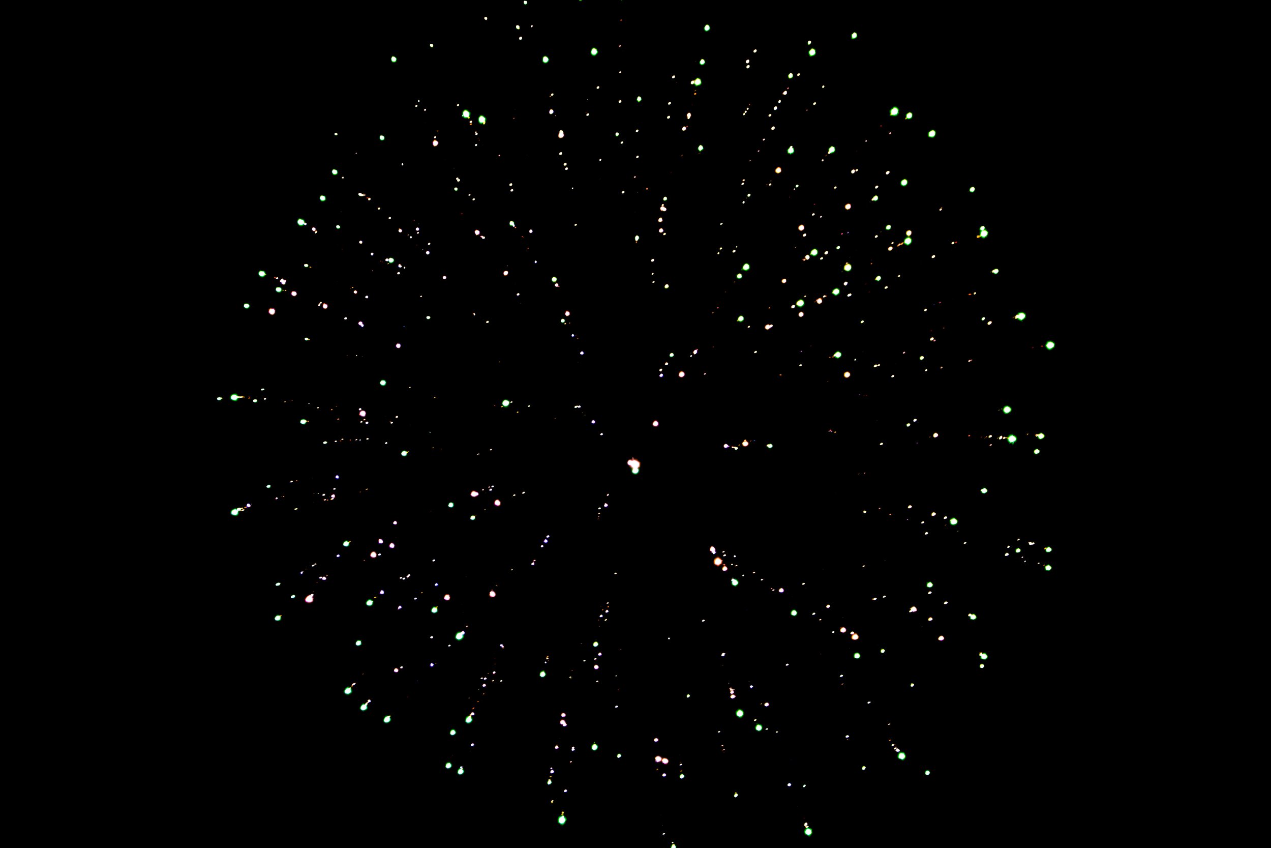 Fireworks exploding in the night sky with colorful sparks.