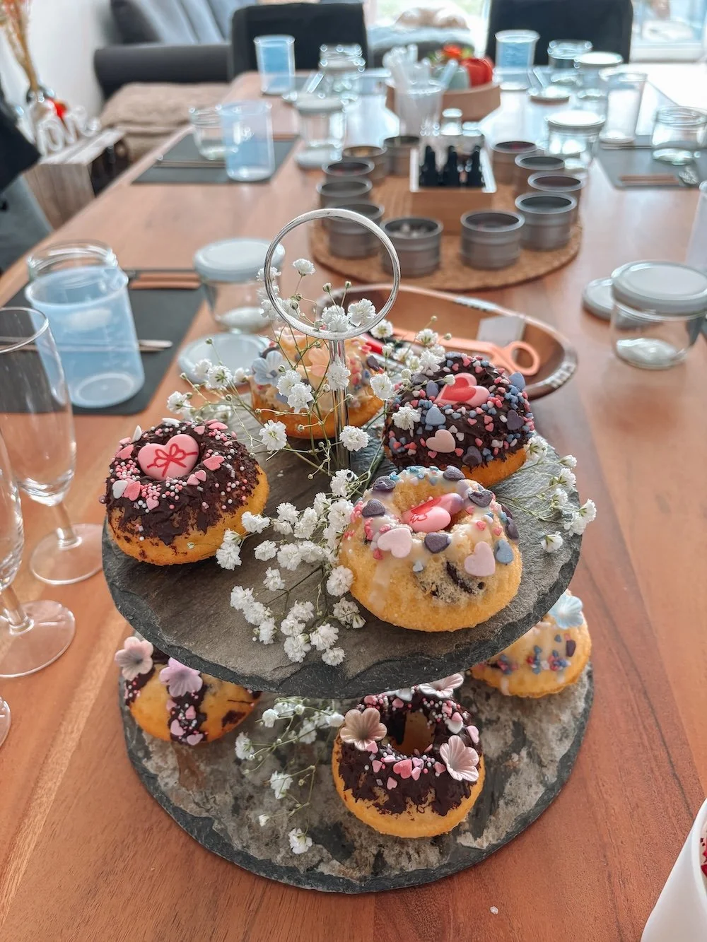 Auf einem Tortenständer sind bunt dekorierte Backwaren angerichtet zu einem JGA-Event.