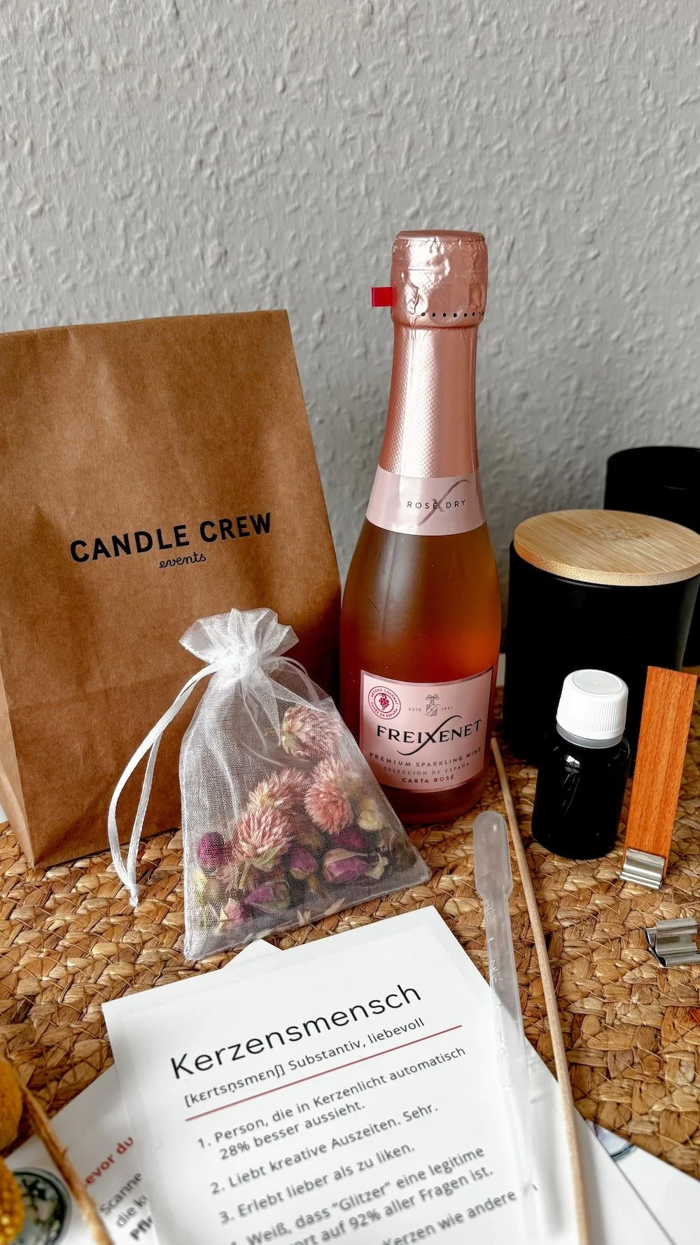 Die DIY-Box der Candle Crew mit Sektflasche und Begrüßungsschreiben.