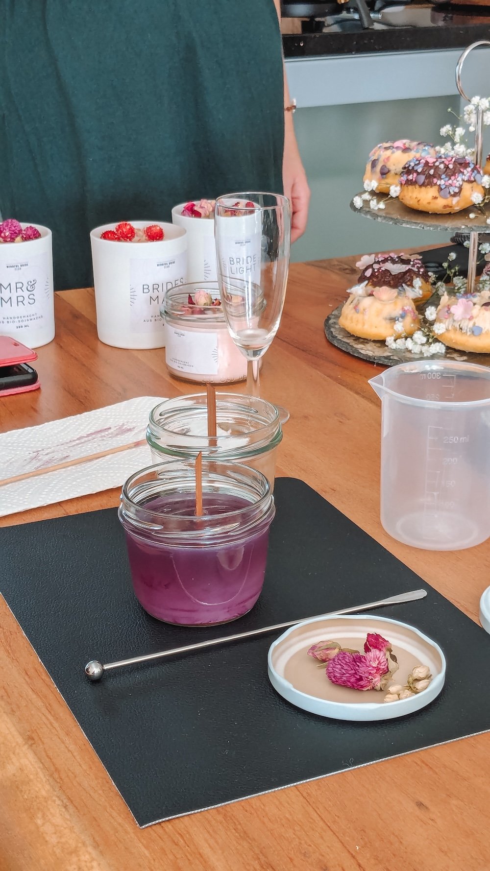 Auf einem Tisch stehen Sektgläser, Kerzen und verschiedene Backwaren.