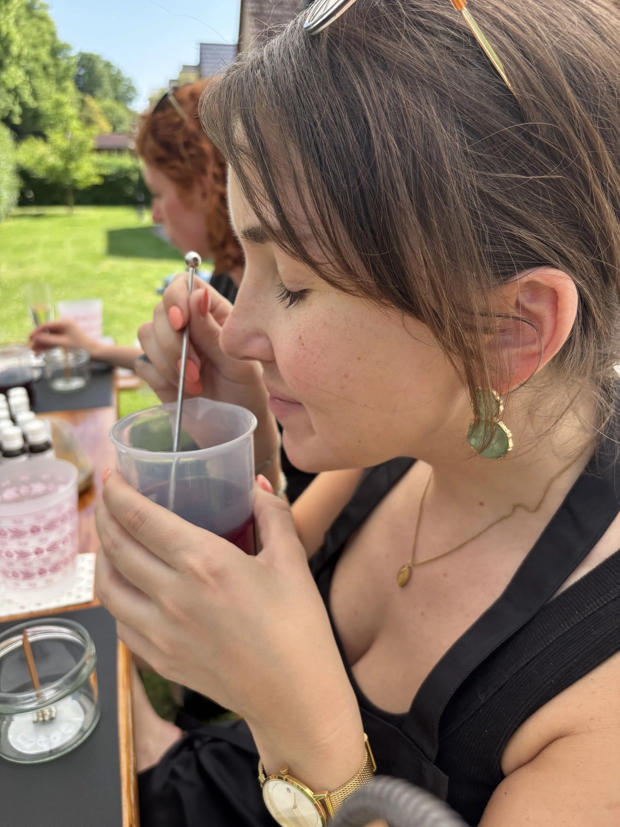 Kerzenworkshop-Teilnehmerin genießt den Geruch des geschmolzenen Wachses.