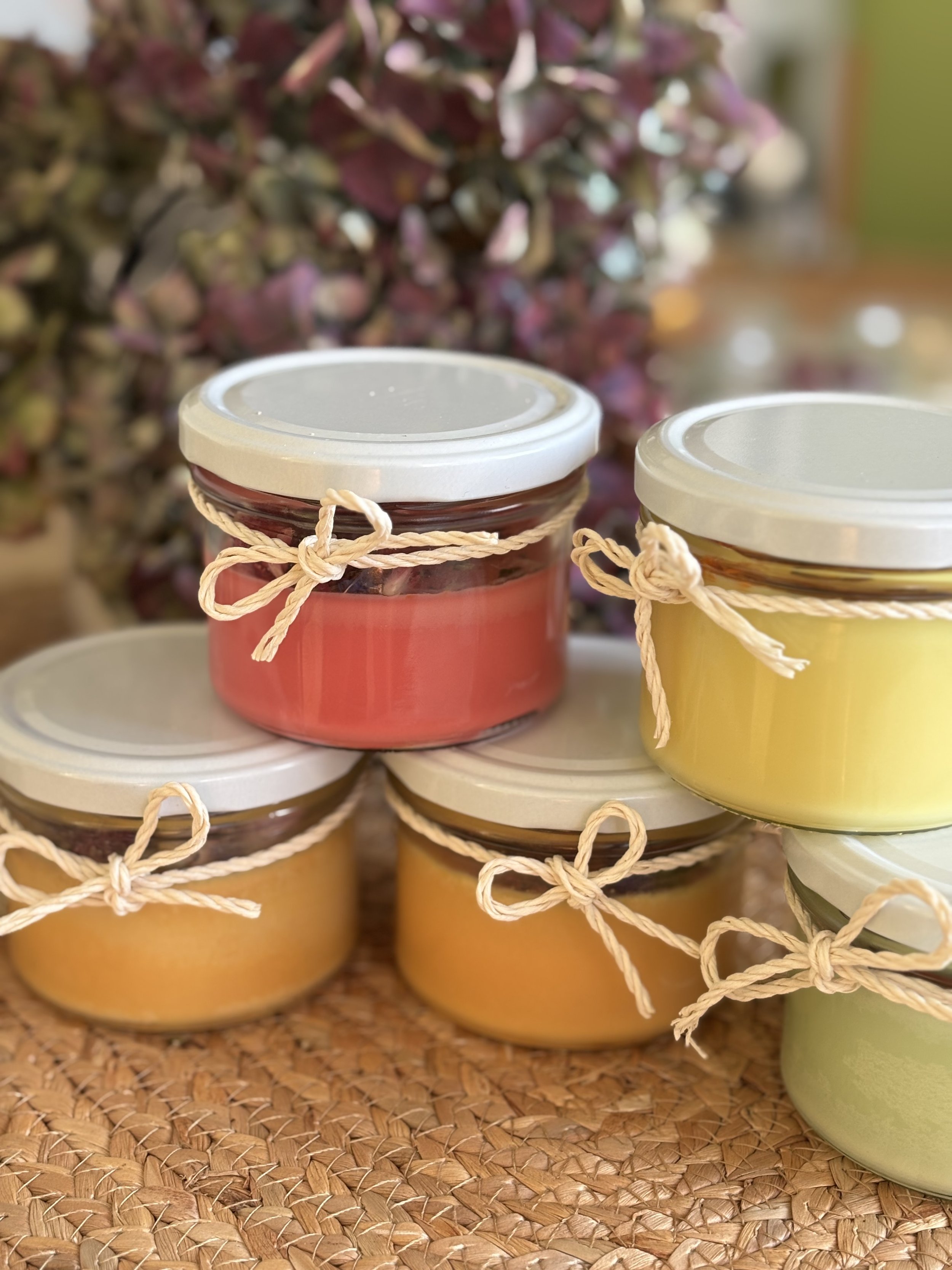 Fertige Kerzen des DIY-Workshops mit Schraubverschlüssen und dekorativen Schleifen.