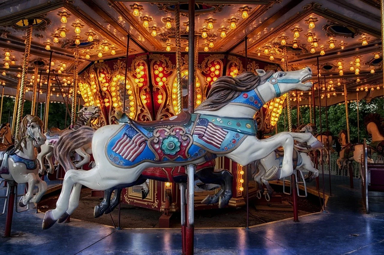 Colorful vintage carousel with decorated horses and illuminated lights at night.