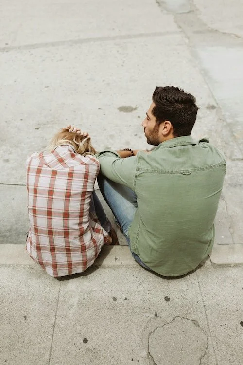Couple sitting on a curb in the middle of a difficult conversation