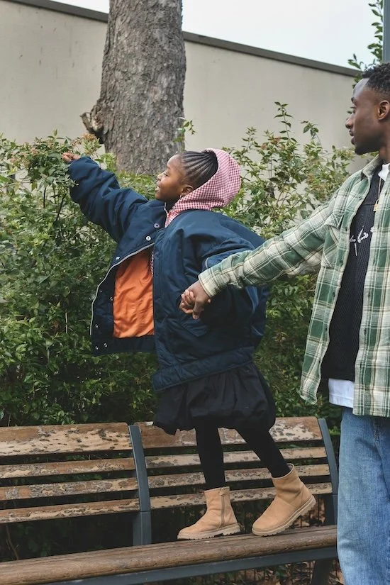 Father and young daughter holding hands and talking during a walk outside