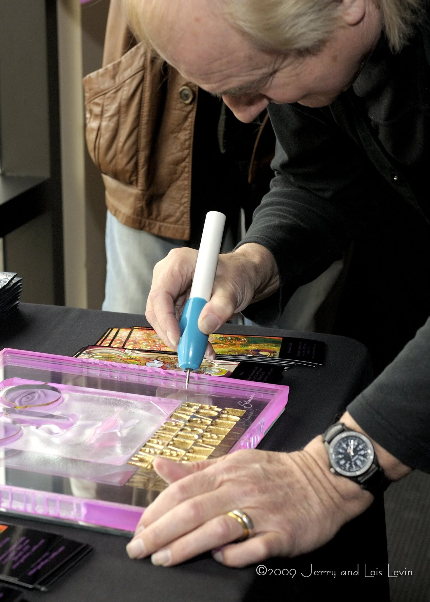 Alan White signing John Lennon portrait at the Susan G. Komen Fundraiser
