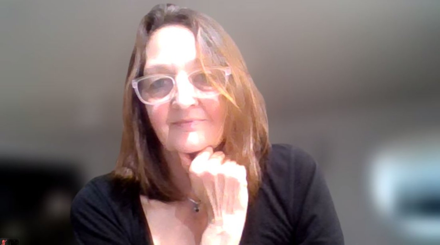 Illustration of a house with a sun and rays inside it, depicted with orange line art on a black background.