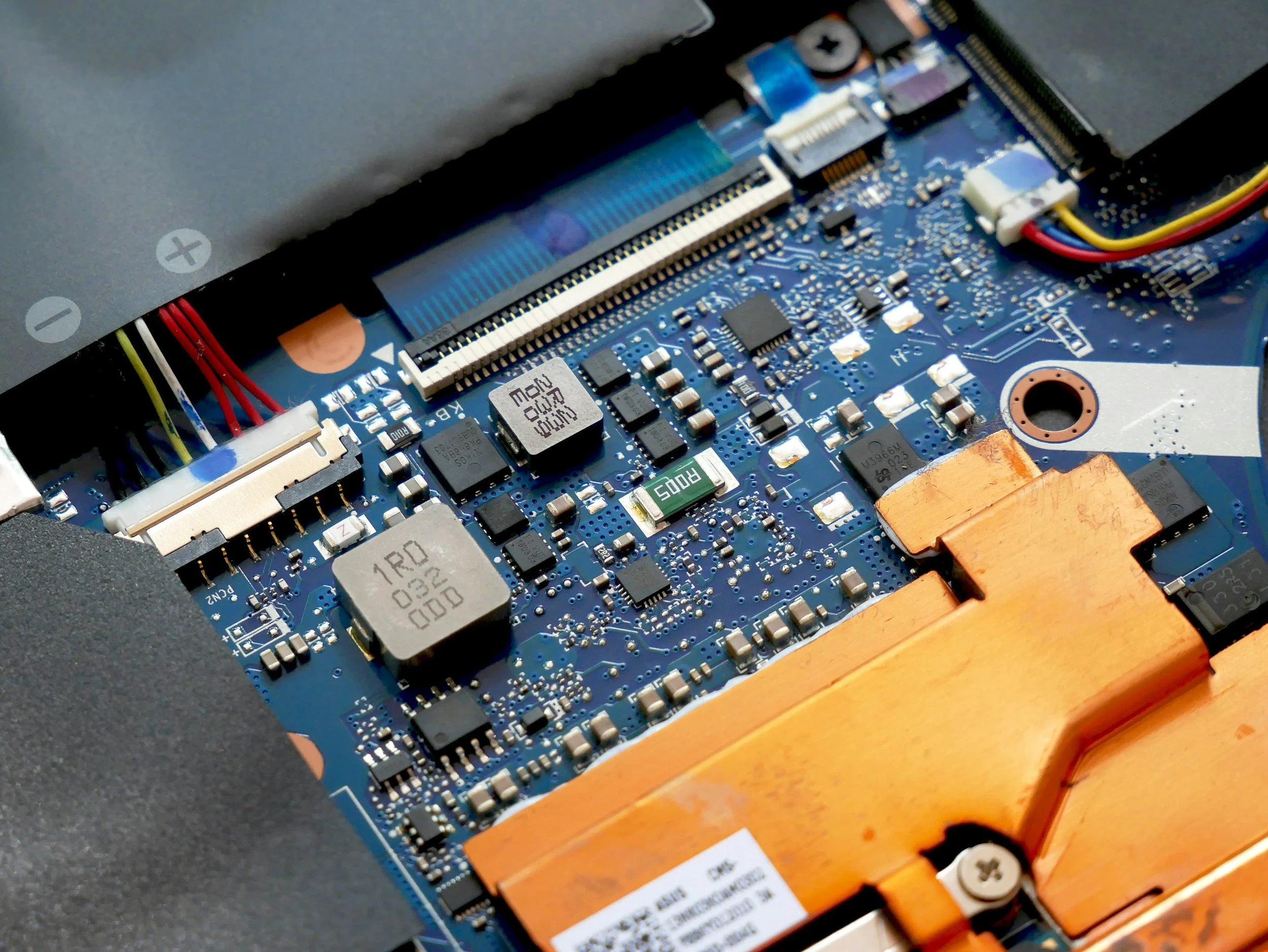 Close-up view of a computer motherboard with various electronic components, including capacitors, resistors, and connectors.