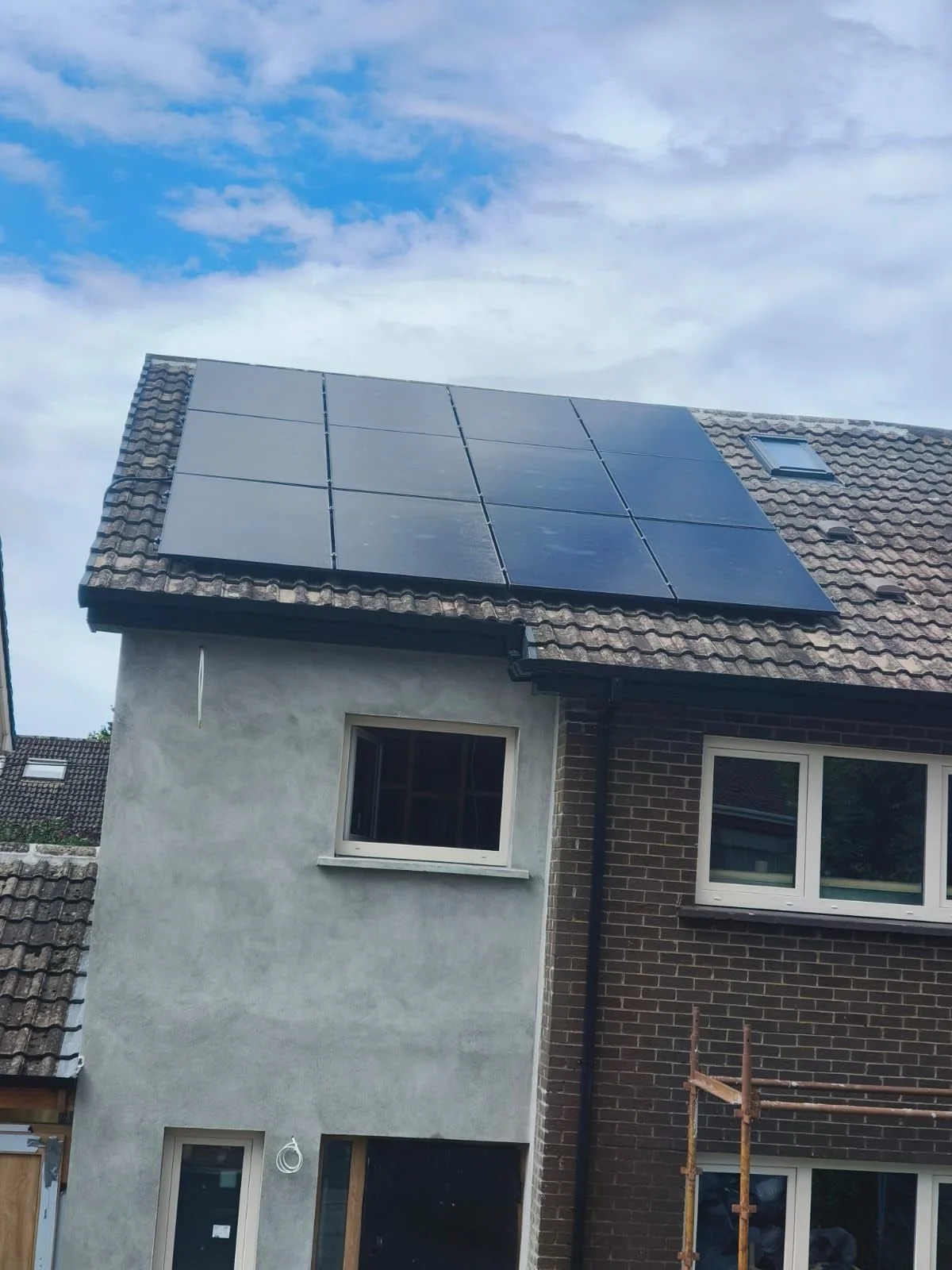 Photograph of a house with solar panels installed on the roof.