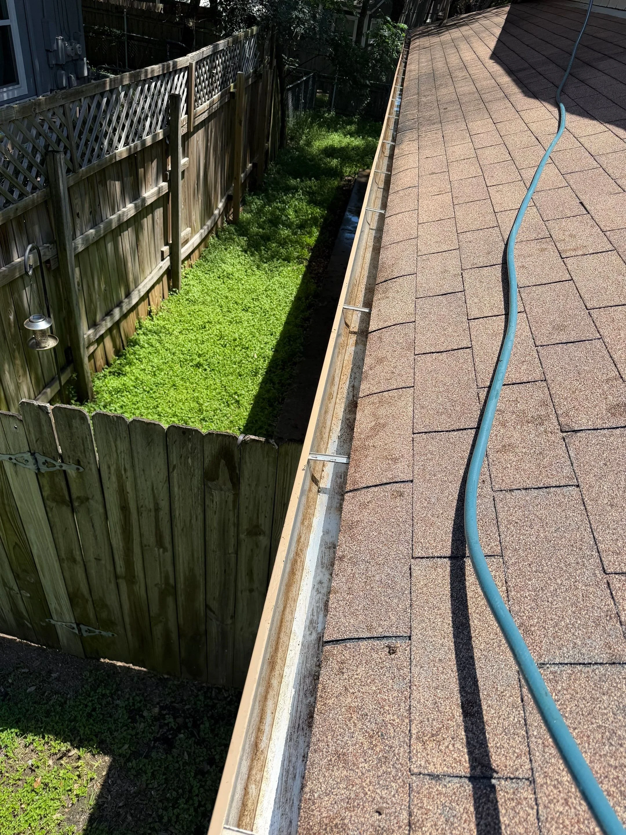 View of a cleaned out gutter no longer filled with debris.
