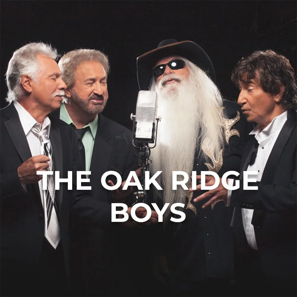 Four men dressed in tuxedos singing into a microphone, one with long white beard and hair, wearing sunglasses and a wide-brimmed hat, with the text "The Oak Ridge Boys" overlaid.