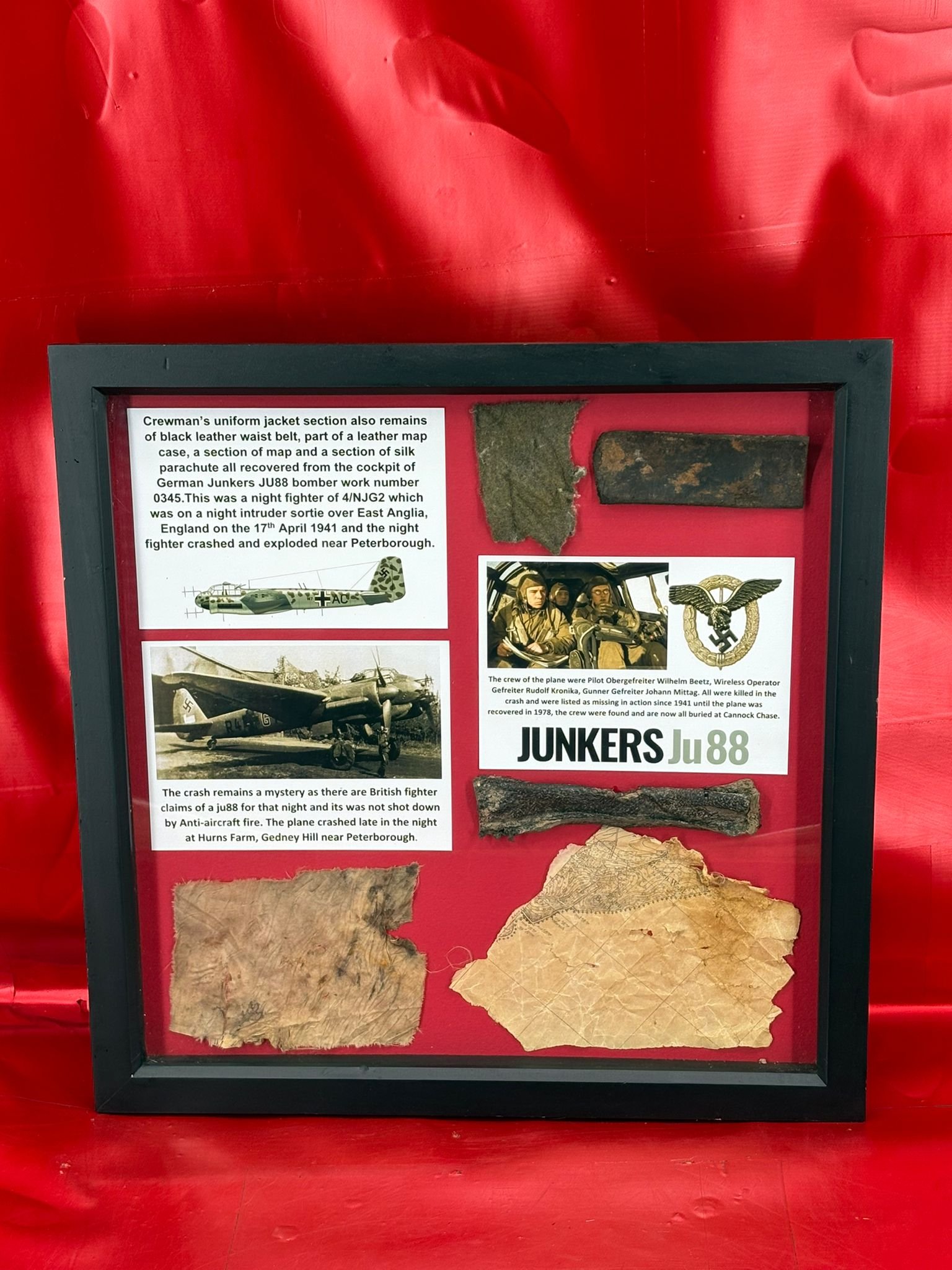 Large glass-framed very rare Crewman’s uniform remains,map and chute from cockpit of German Junkers JU88 bomber work number 0345 of 4/NJG2 on night intruder raid, 17th April 1941,crashed Peterborough