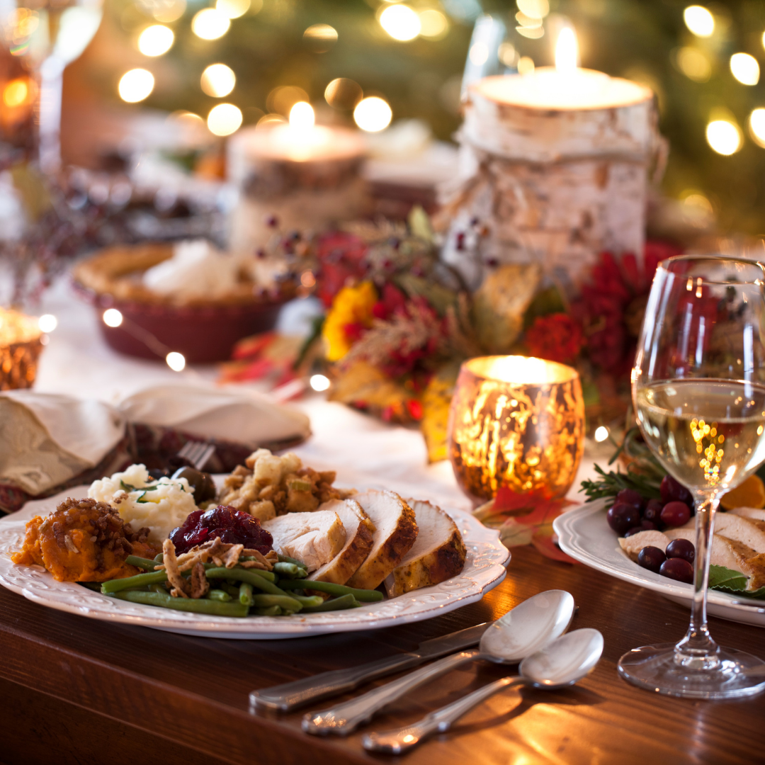 Warm holiday dining scene with turkey, wine, and candles beside a glowing Christmas tree — celebrating luxury seasonal travel with Legacy Reserve Travel.