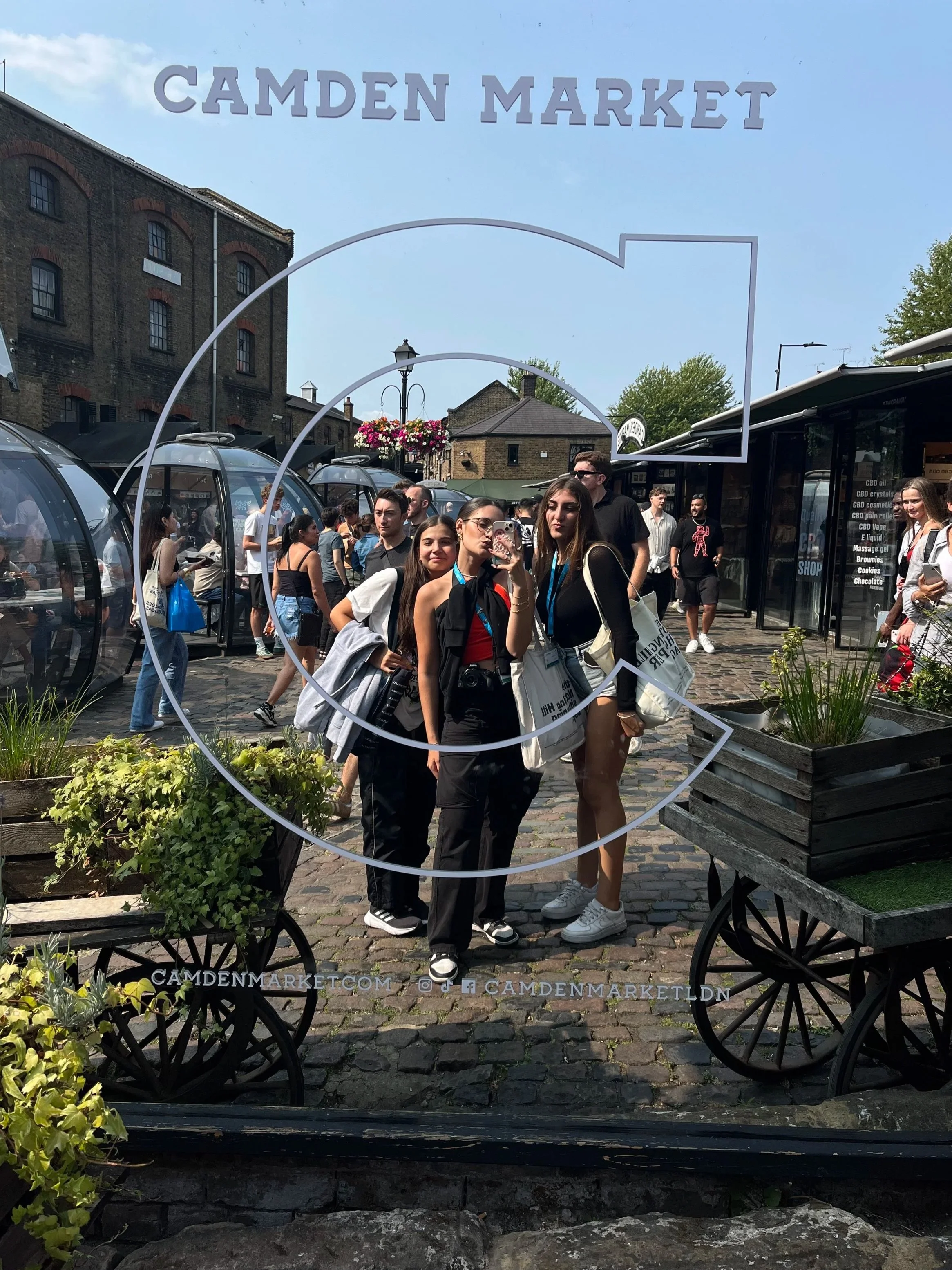 Ragazze che si scattano una foto con uno smartphone davanti all'ingresso di Camden Market.