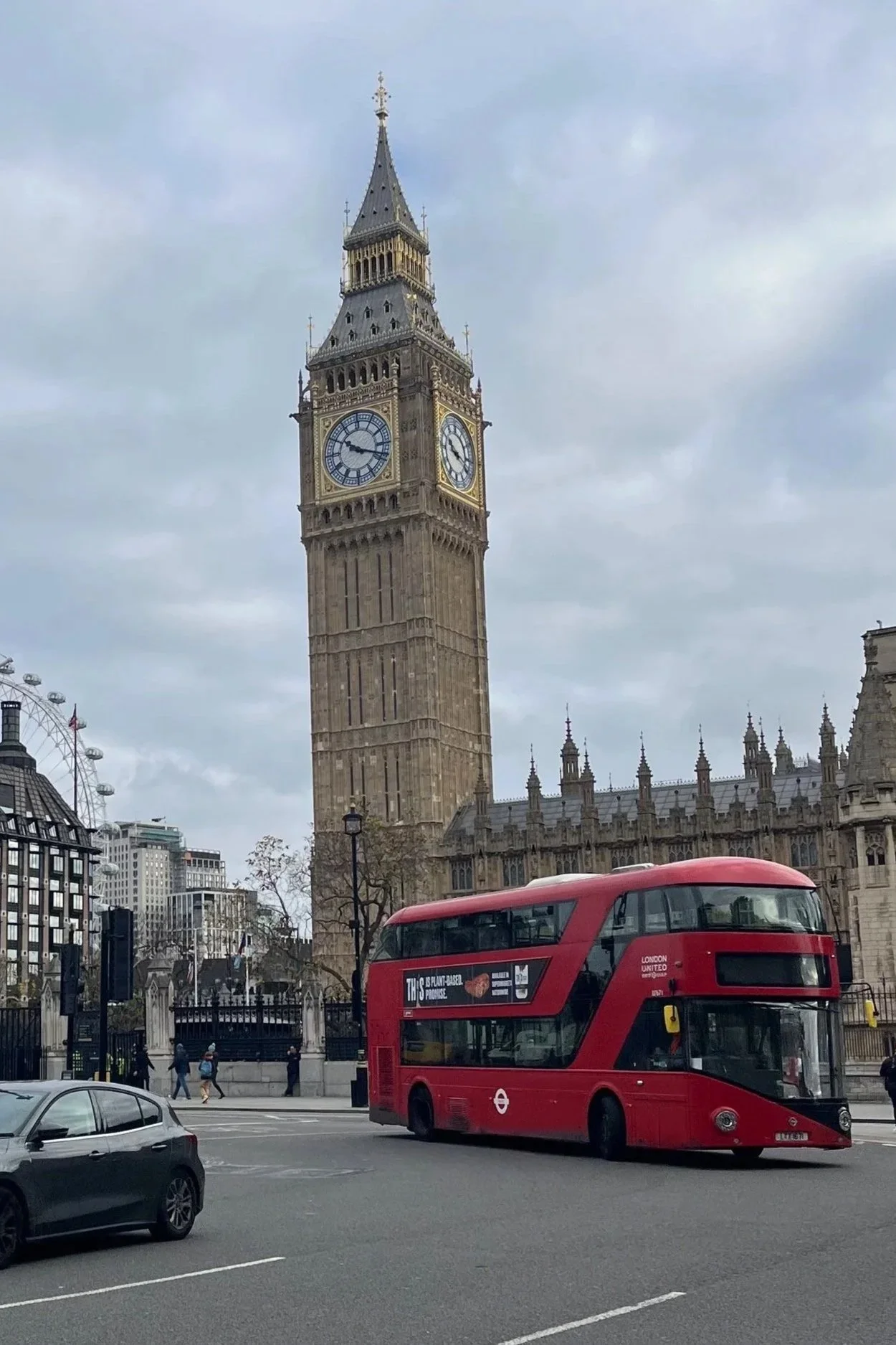 Immagine di Big Ben e di un autobus rosso a Londra, con alcune persone e auto sulla strada.