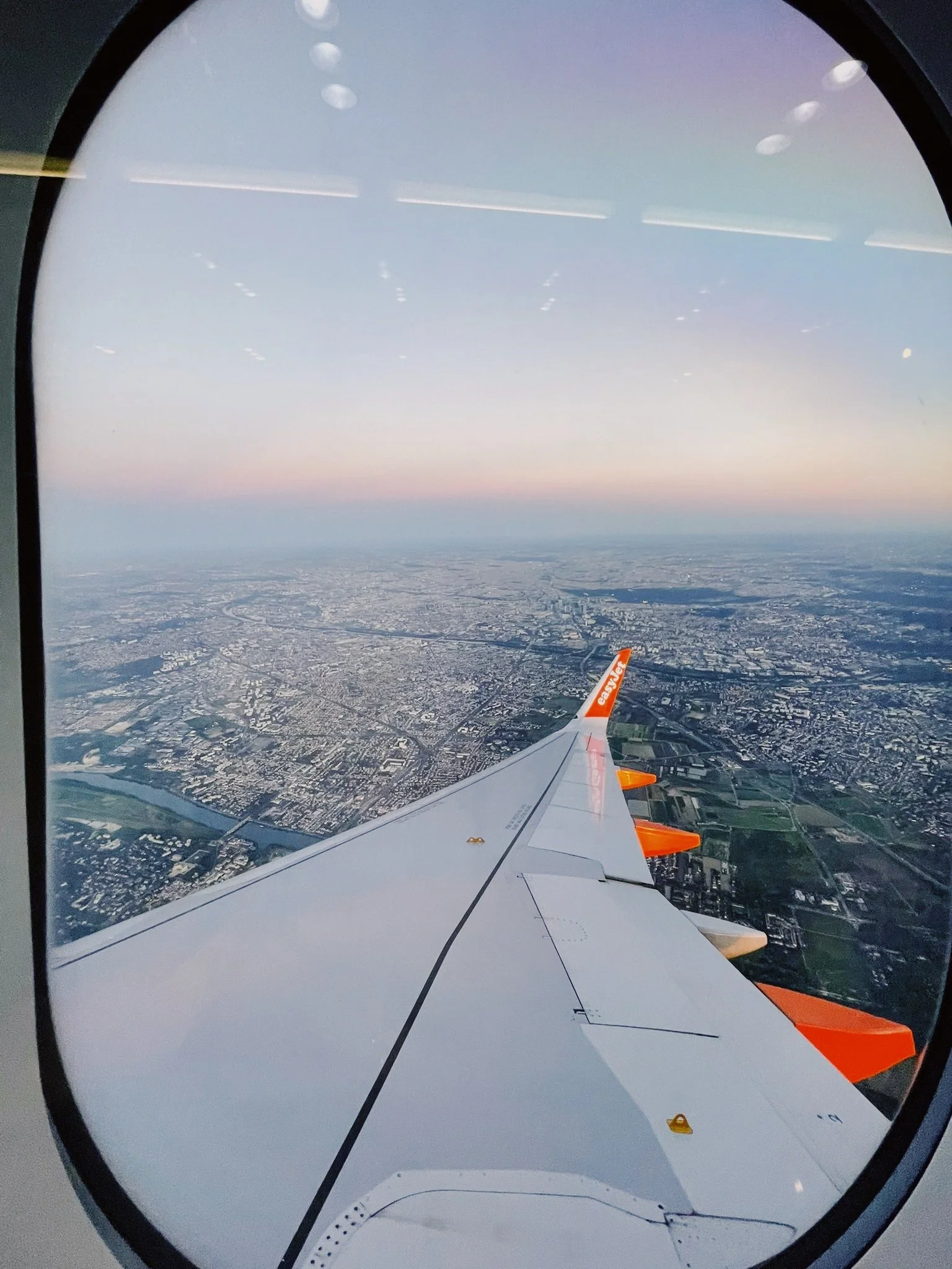 Vista dall'aereo con vista sul paesaggio urbano e campagnolo sottostante, vista attraverso la finestra dell'aereo.