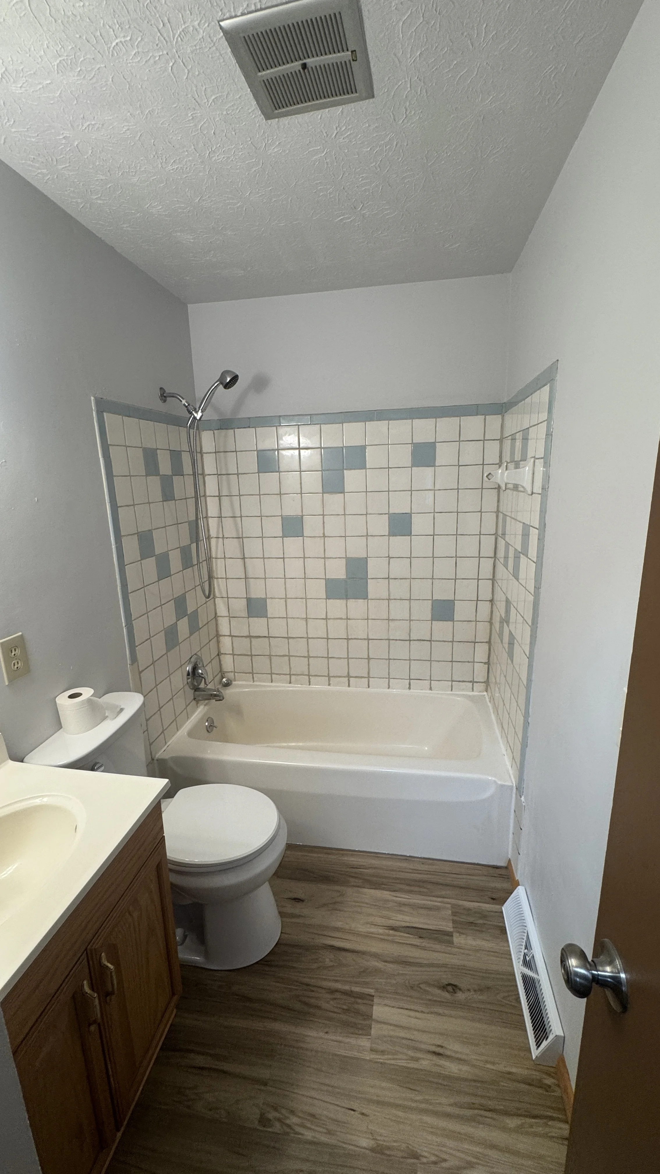 After Photo - Bathroom with new toilet, vanity faucet, light fixture & flooring