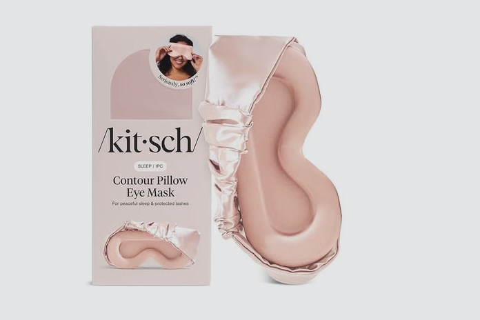 Packaging box and a contoured pillow designed for sleep and eye comfort, with soft pink satin fabric edges.