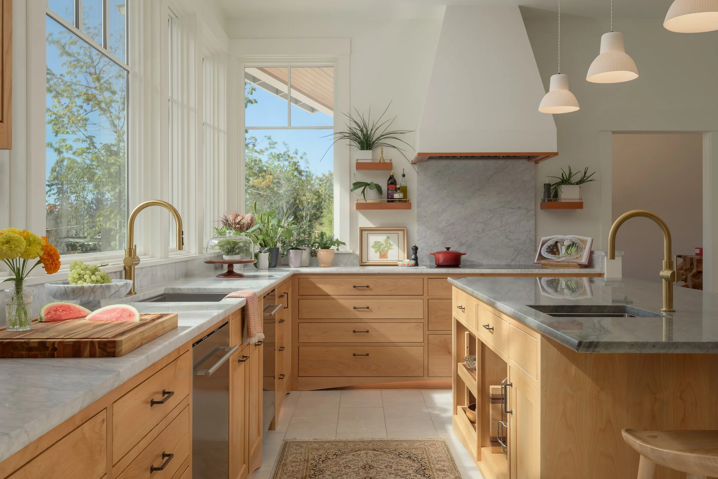 Modern kitchen with marble counters, wood cabinets, and lots of natural light
