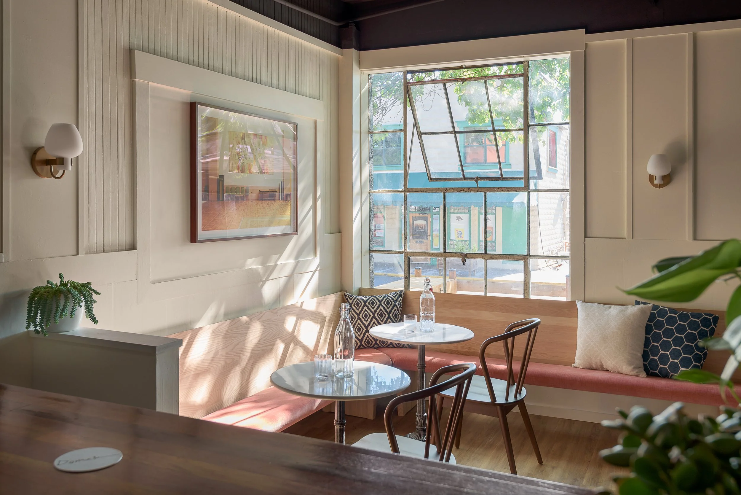 Domek restaurant bar interior in a historic building, with window ajar and tables ready for dinner guests