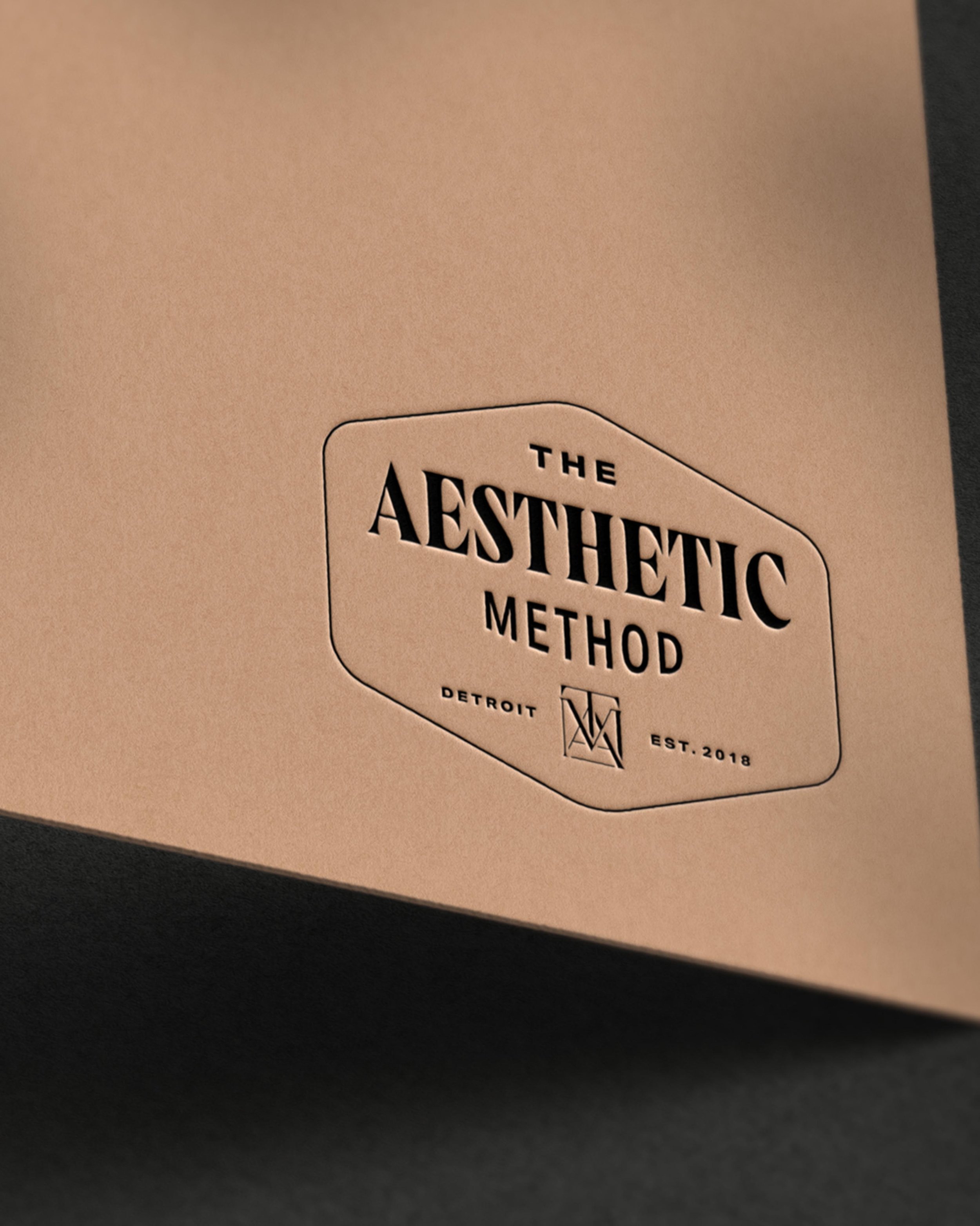 The Aesthetic Method logo embossed on cardstock