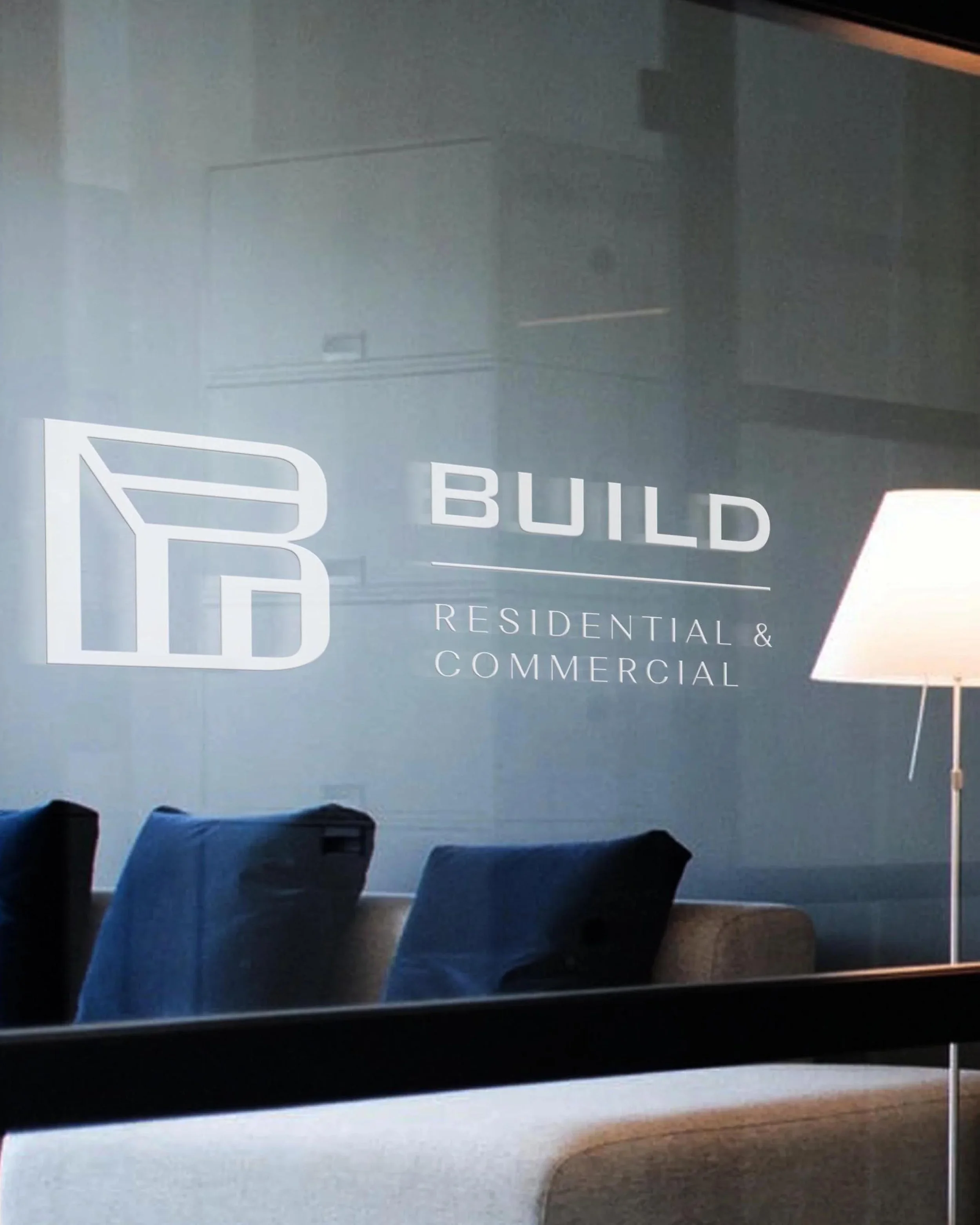 indoor signage displaying "Build Residential & Commercial Construction" on a glass window