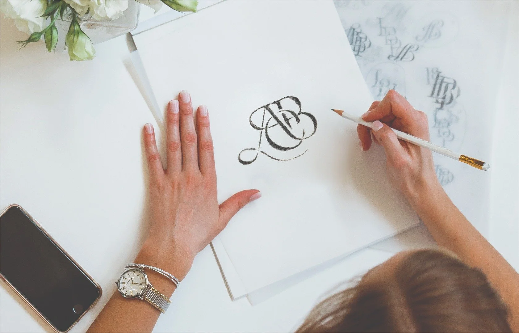 brand designer sketching a monogram with letters ACB