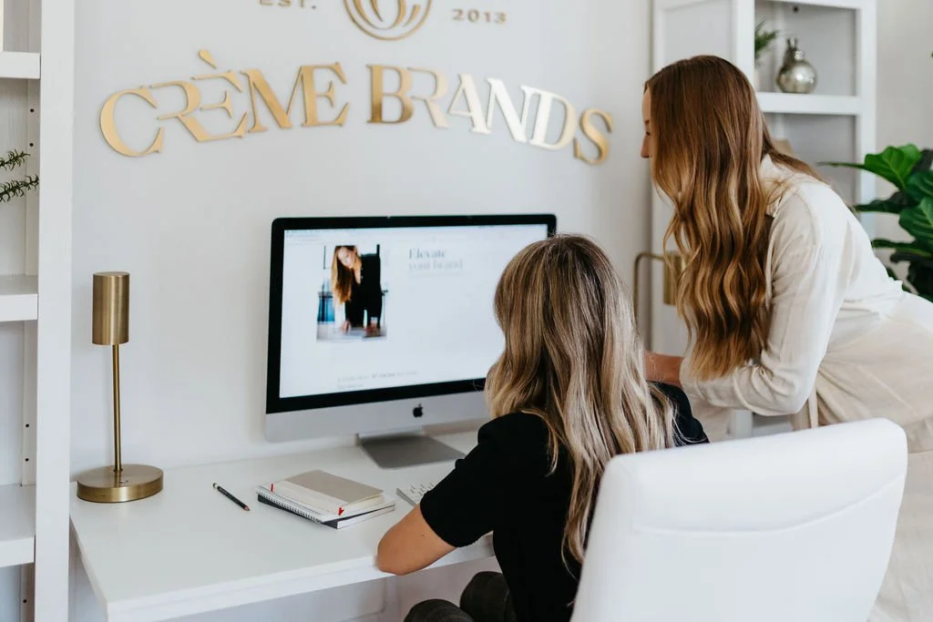 Creme website designers gathered around a computer