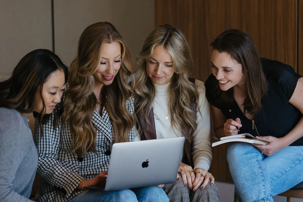 Creme Brands web designers gathered around a laptop