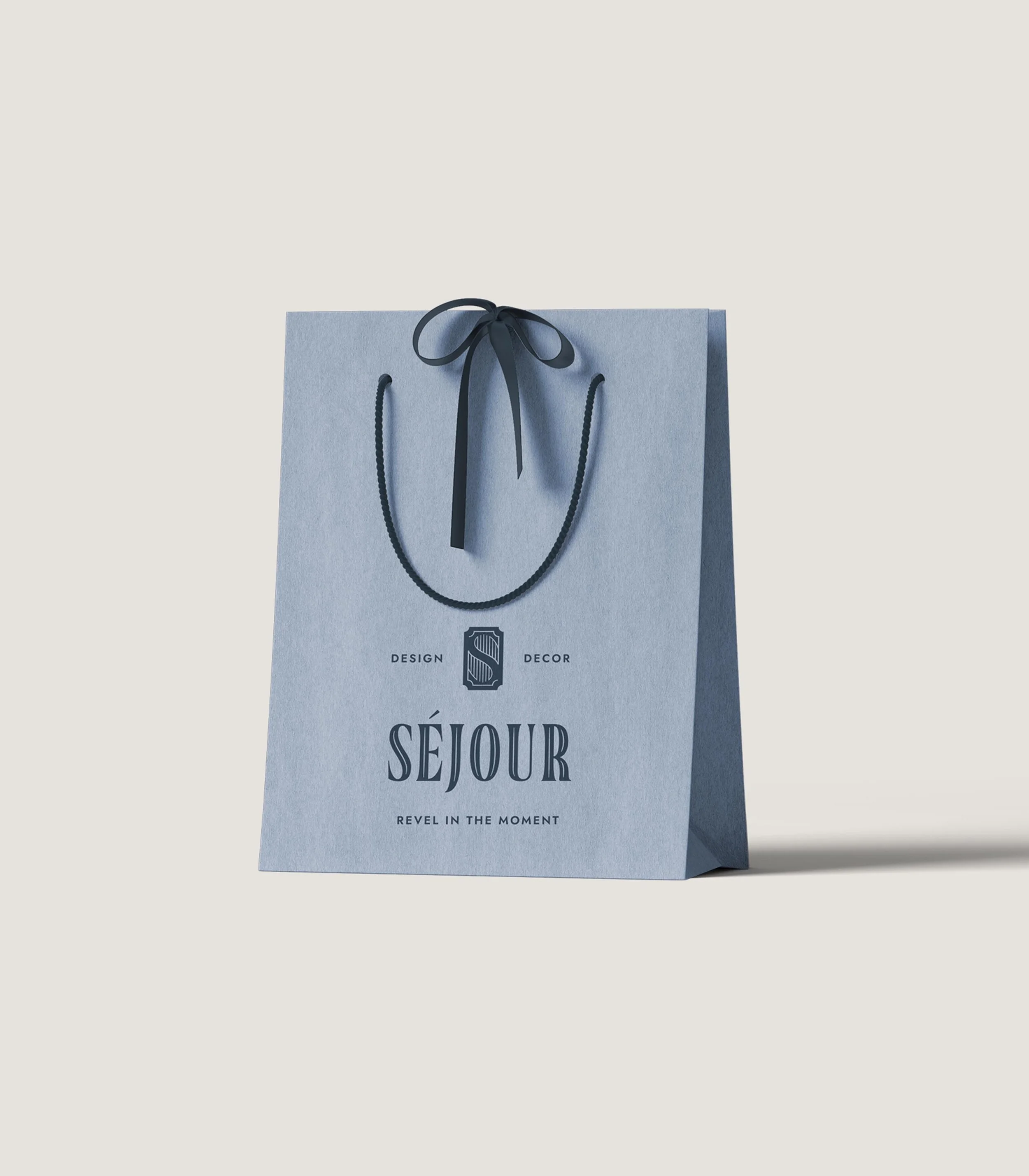 Sejour Events logo on a blue gift bag design