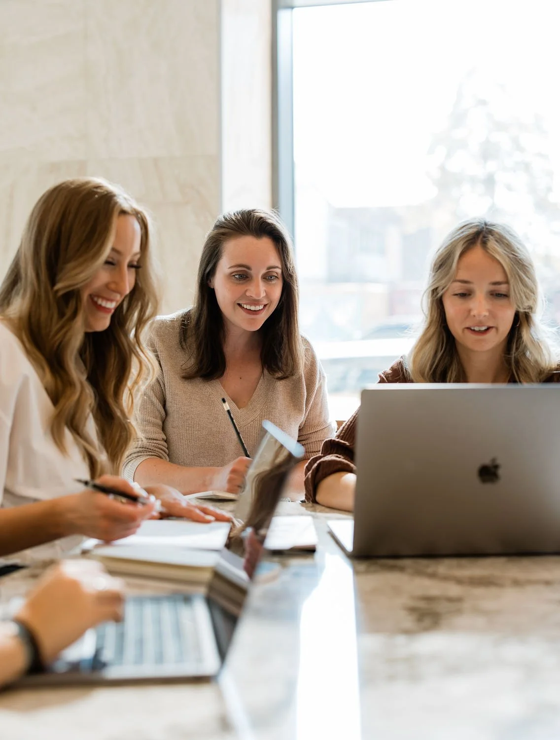 Creme Brands team meeting around a laptop