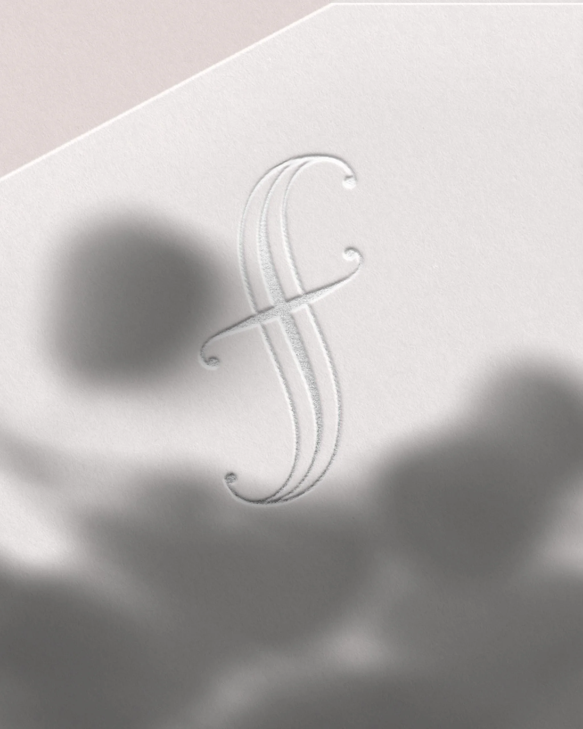 "F" icon embossed on cardstock in silver foil