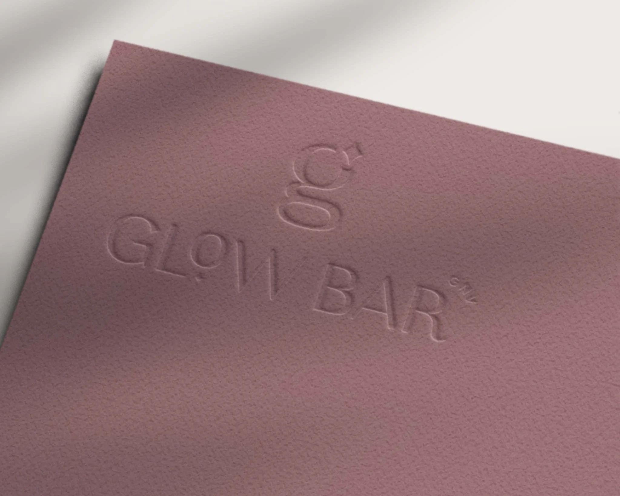 Glow Bar logo embossed on pink cardstock